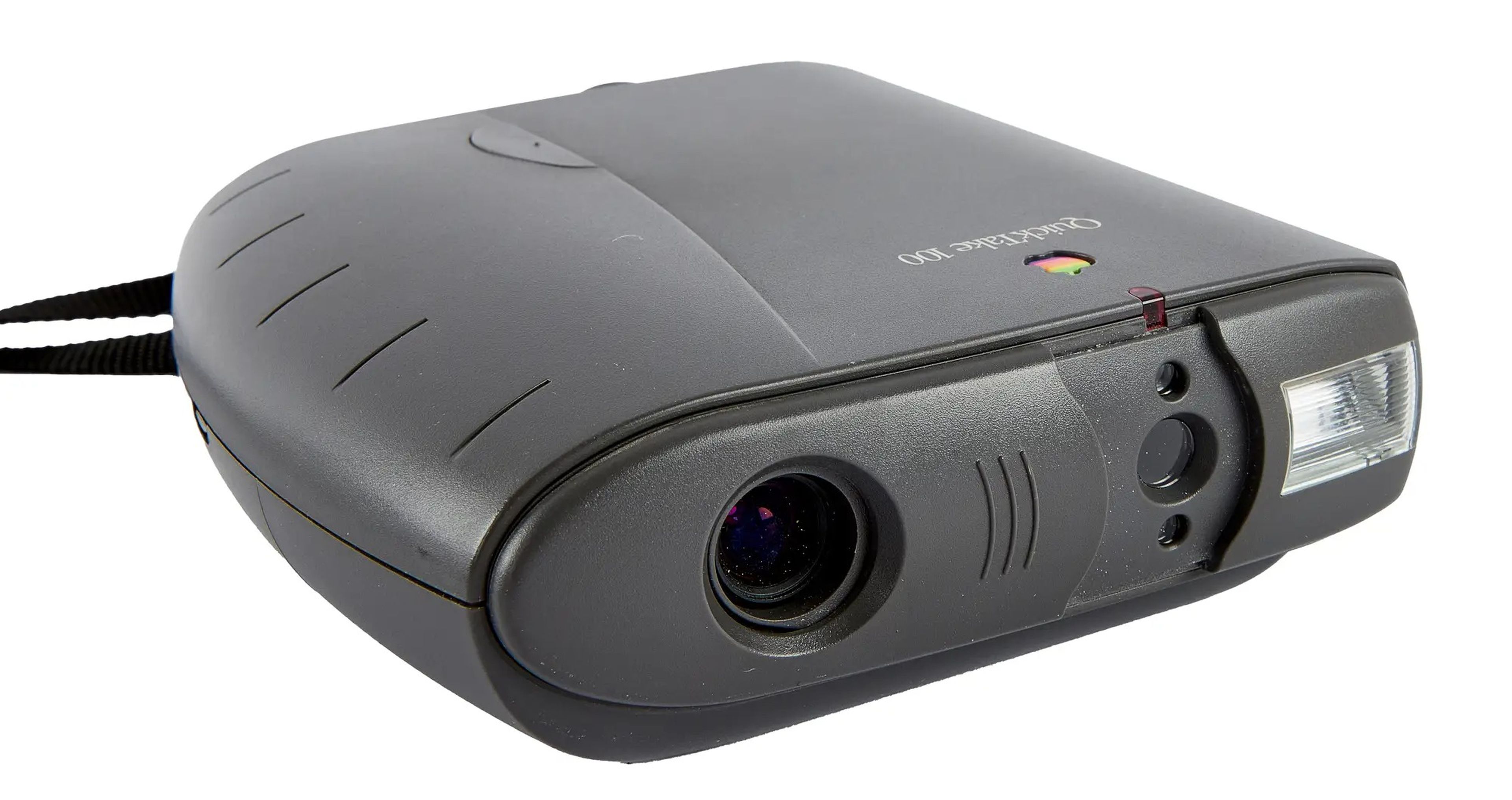 photo of 1994 Apple QuickTake 100 which is flat camera with a flash on the right and a lens on the left, a neck strap is seen in the background