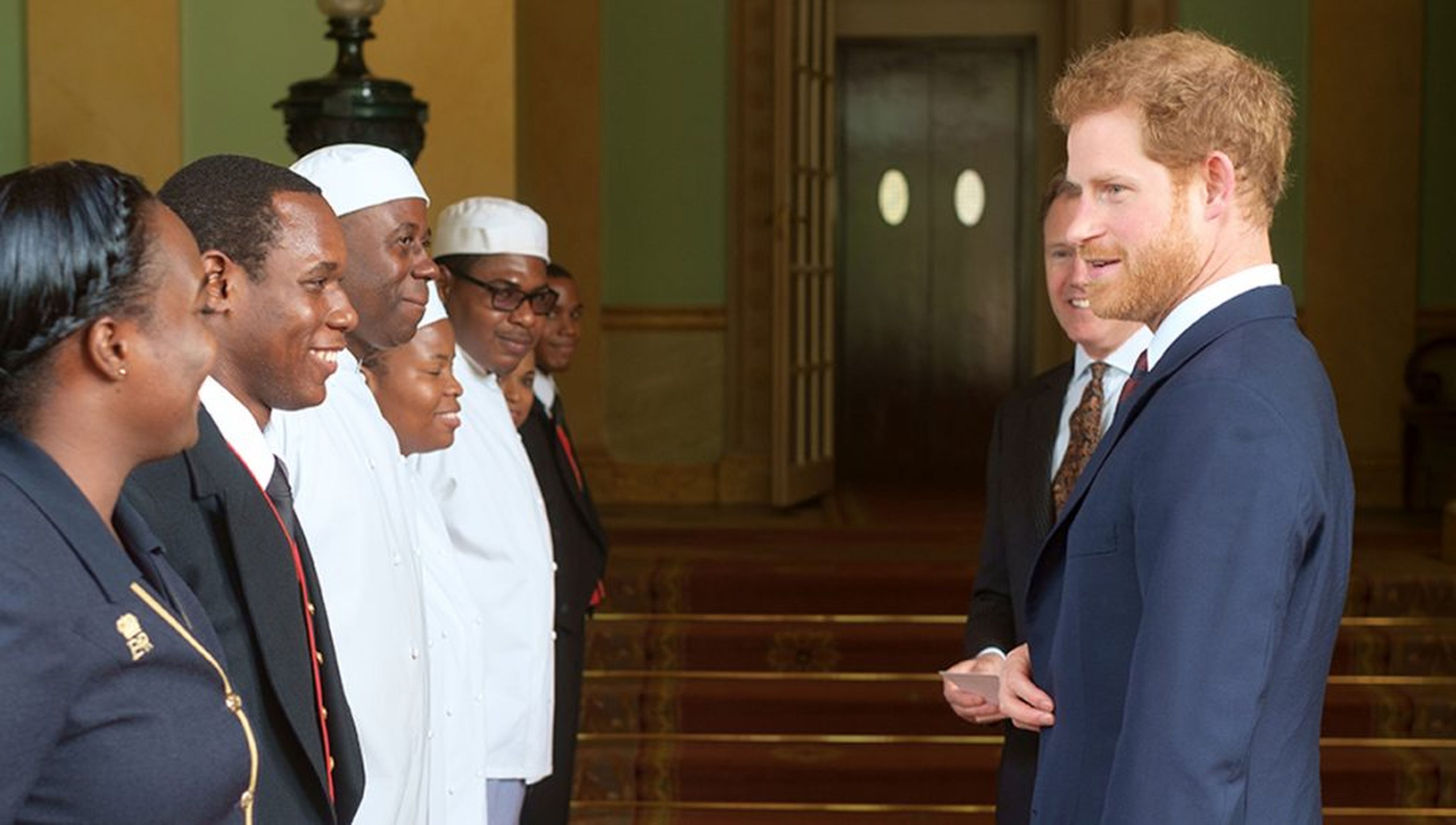 El príncipe Harry frente a parte del personal del Palacio de Buckingham.