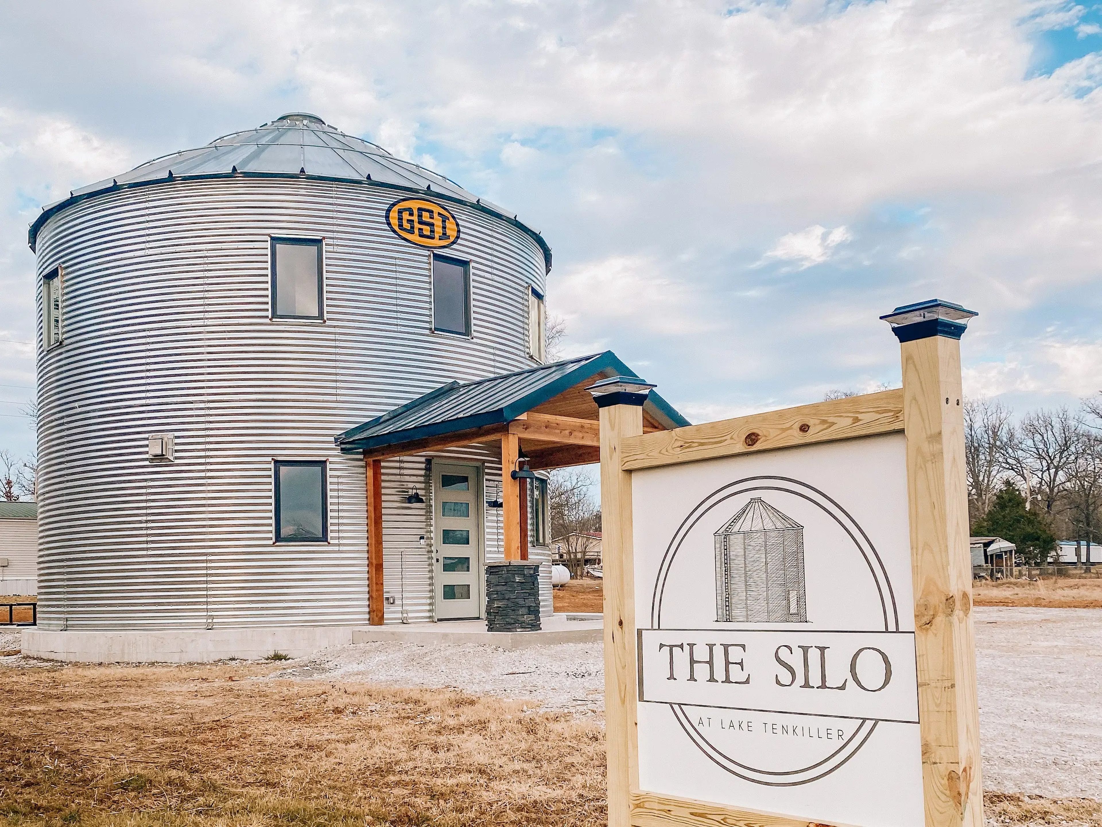 A sign on the property showing "The Silo" logo with the home in the background.