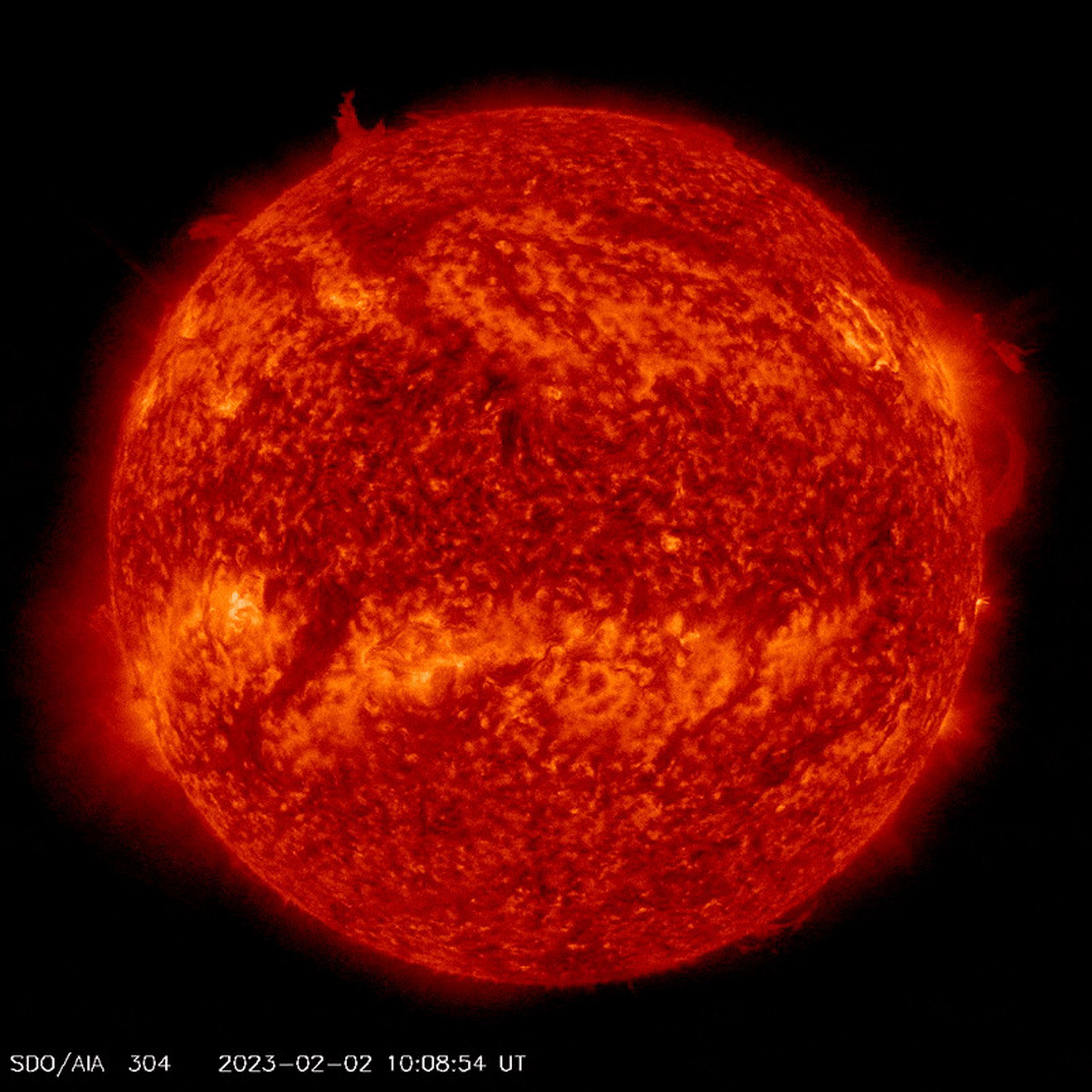 video shows sun rotating ball of red plasma with a filament emerging from the top then breaking away and swirling around the north pole