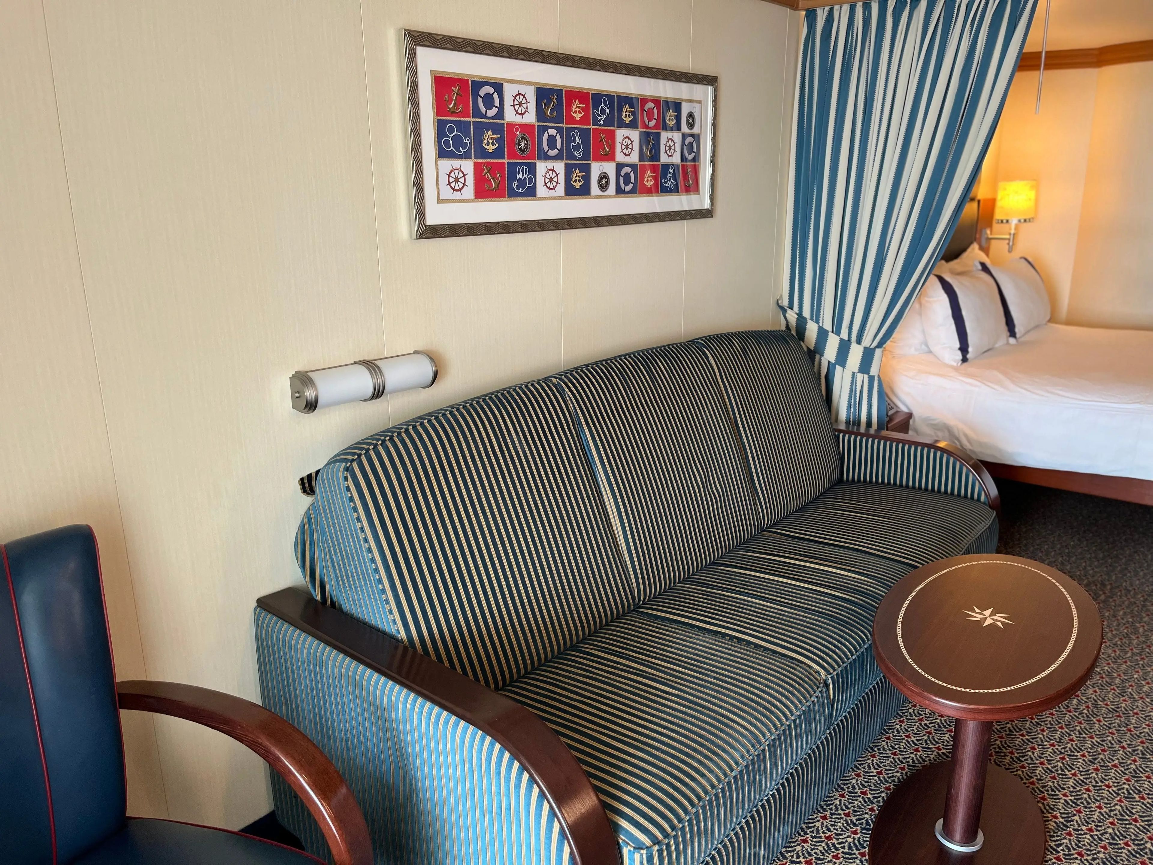 view of the couch next to the bed in a family stateroom on a disney cruise