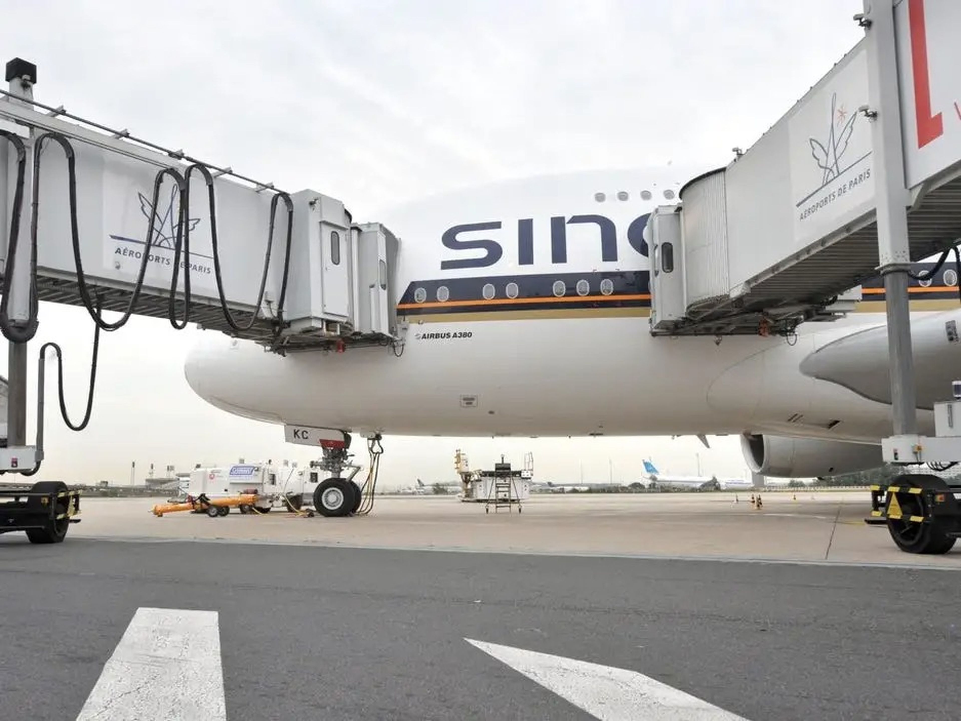 Vista de un A380 de Singapur embarcando por 2 pasarelas inferiores en el aeropuerto CDG de París.