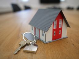 Una casa en miniatura junto a unas llaves.