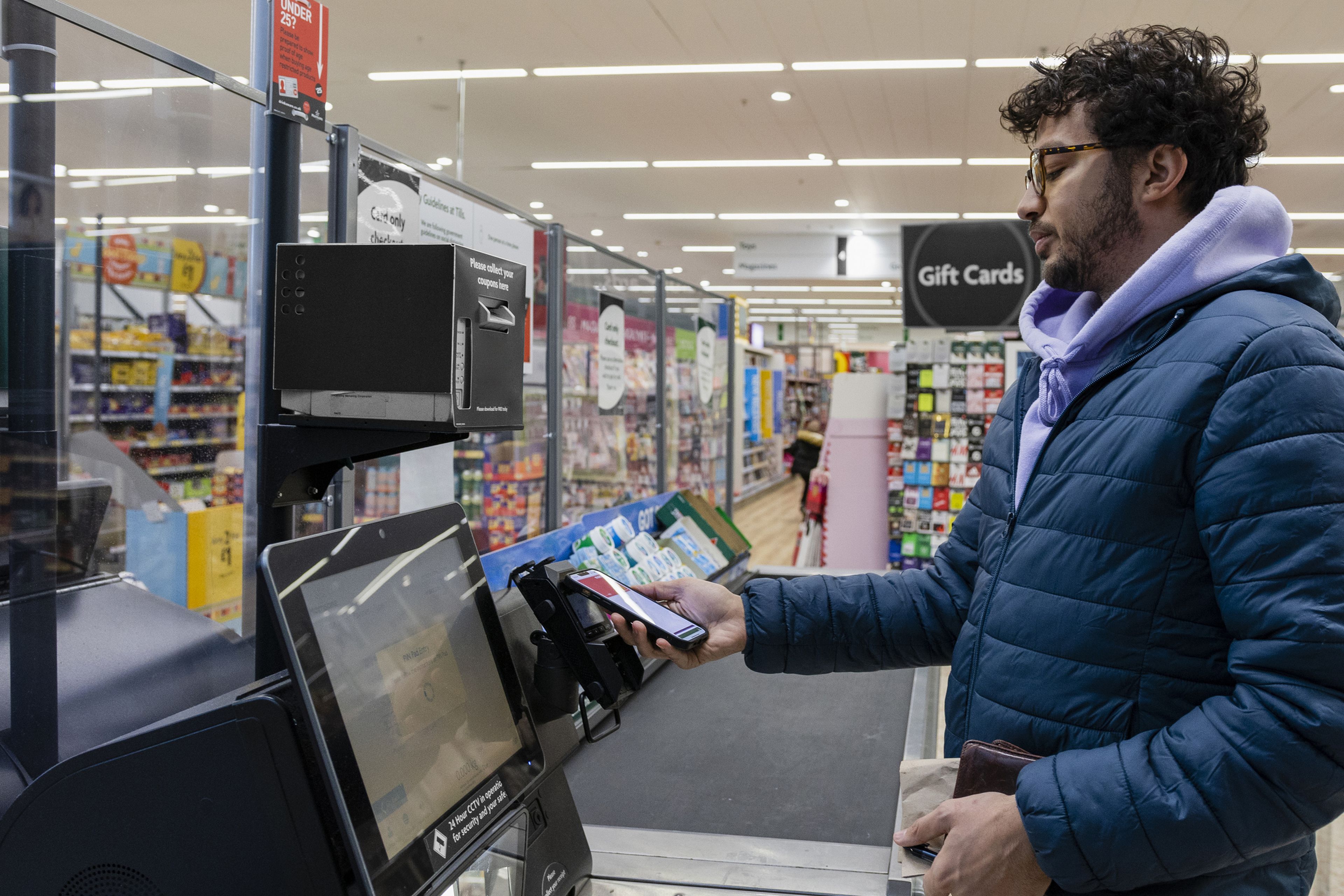 Un chico joven compra en el supermercado en tiempos de inflación.