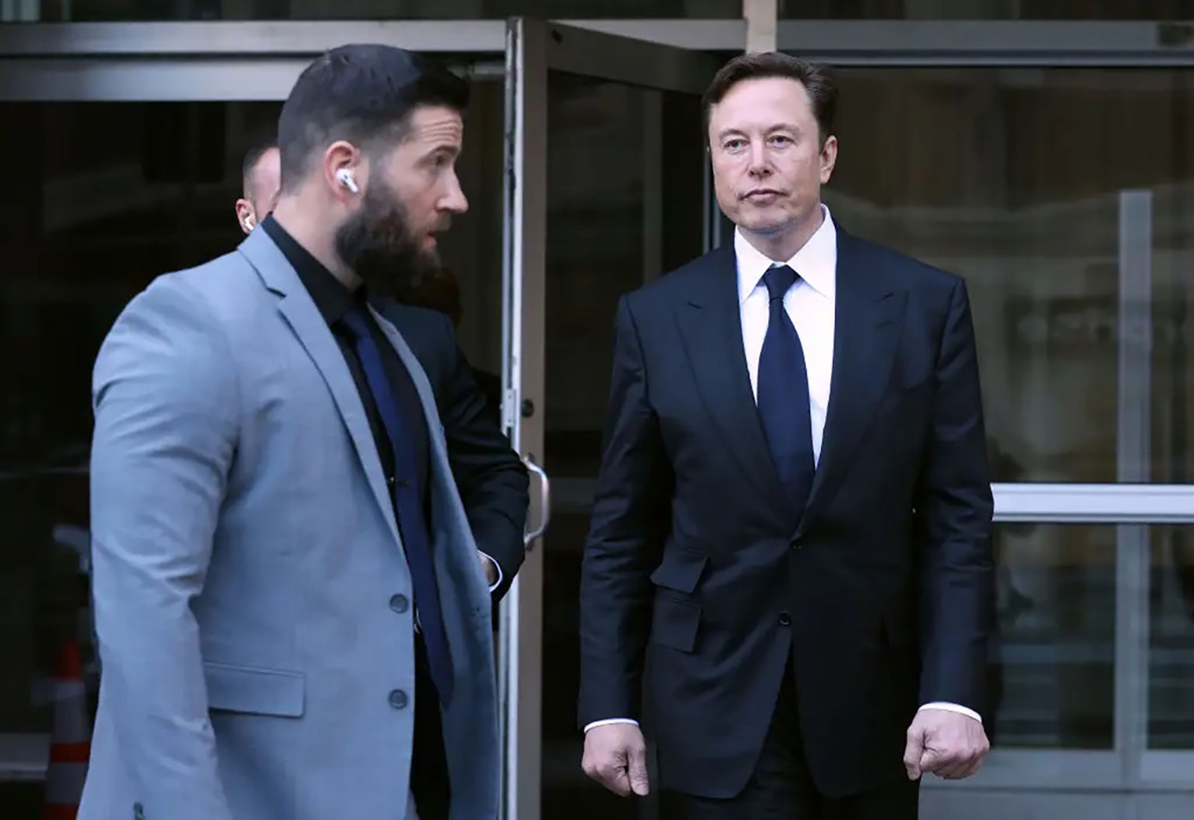 Elon Musk (derecha), CEO y propietario de Twitter, junto a 2 de sus guardaespaldas.