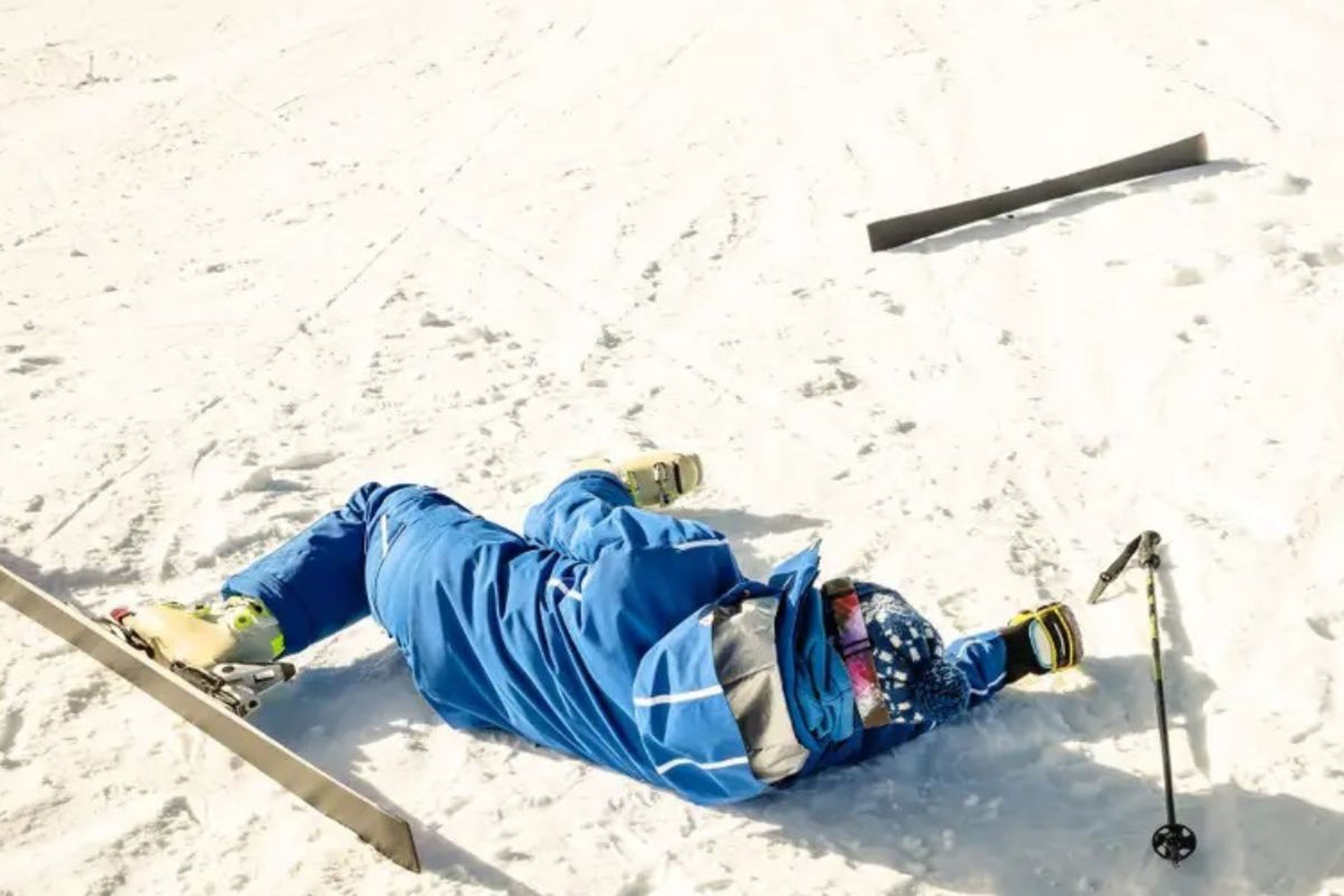 Un esquiador tirado en la nieve.