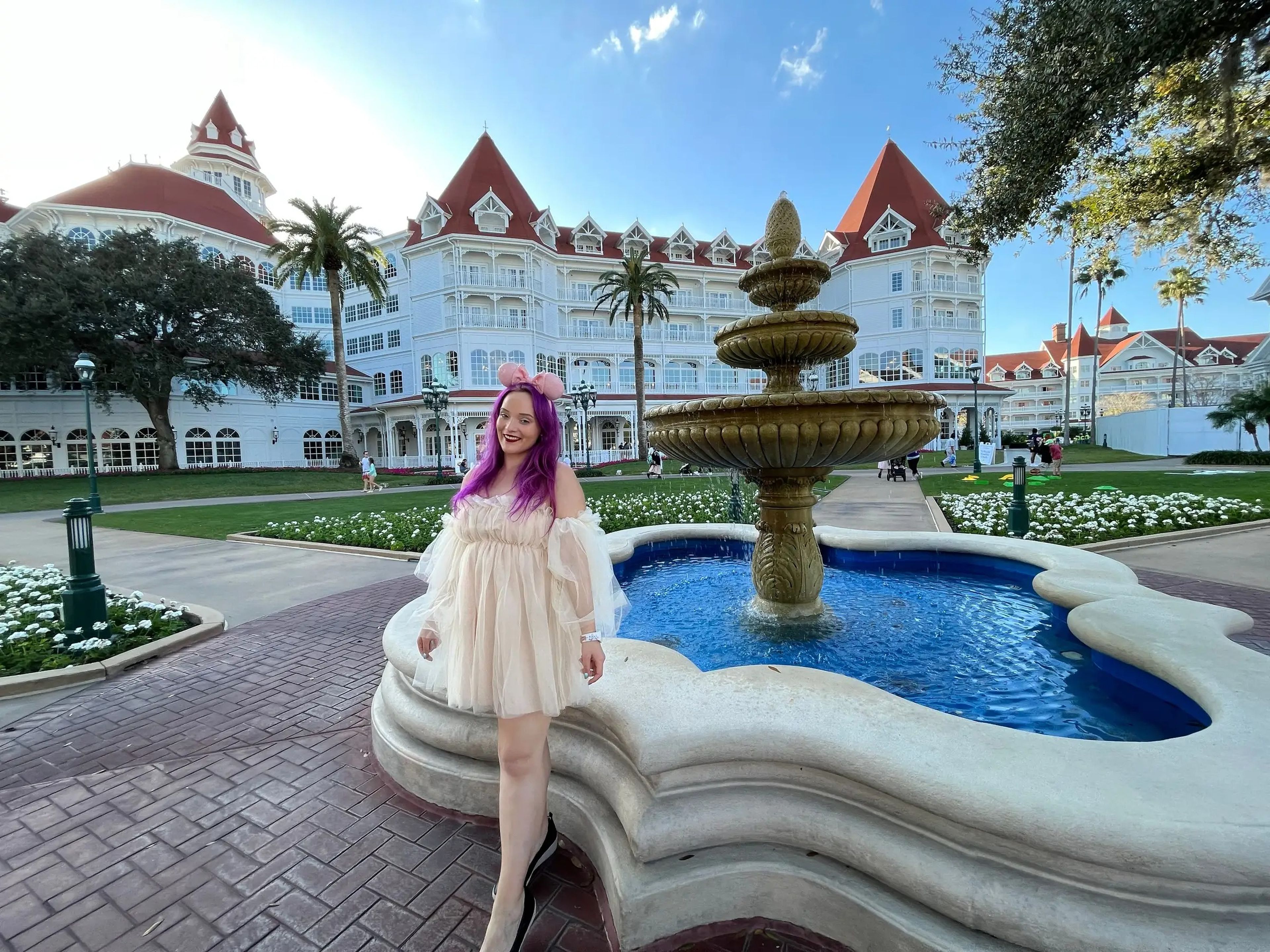 jenna posing for a photo with a fountain on the grounds of the grand floridian resort