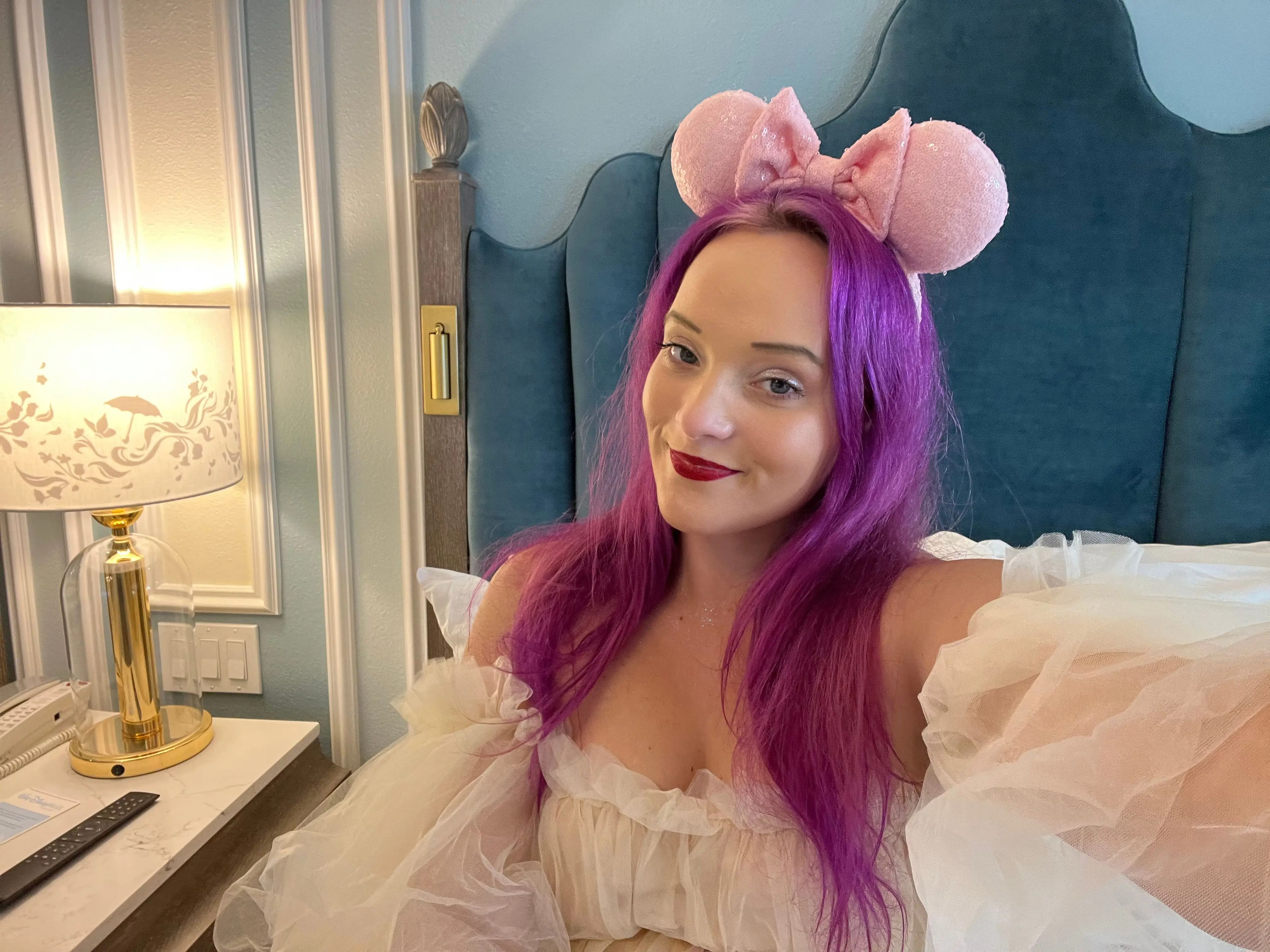 jenna posing for a selfie on a bed in a room at the grand floridian resort