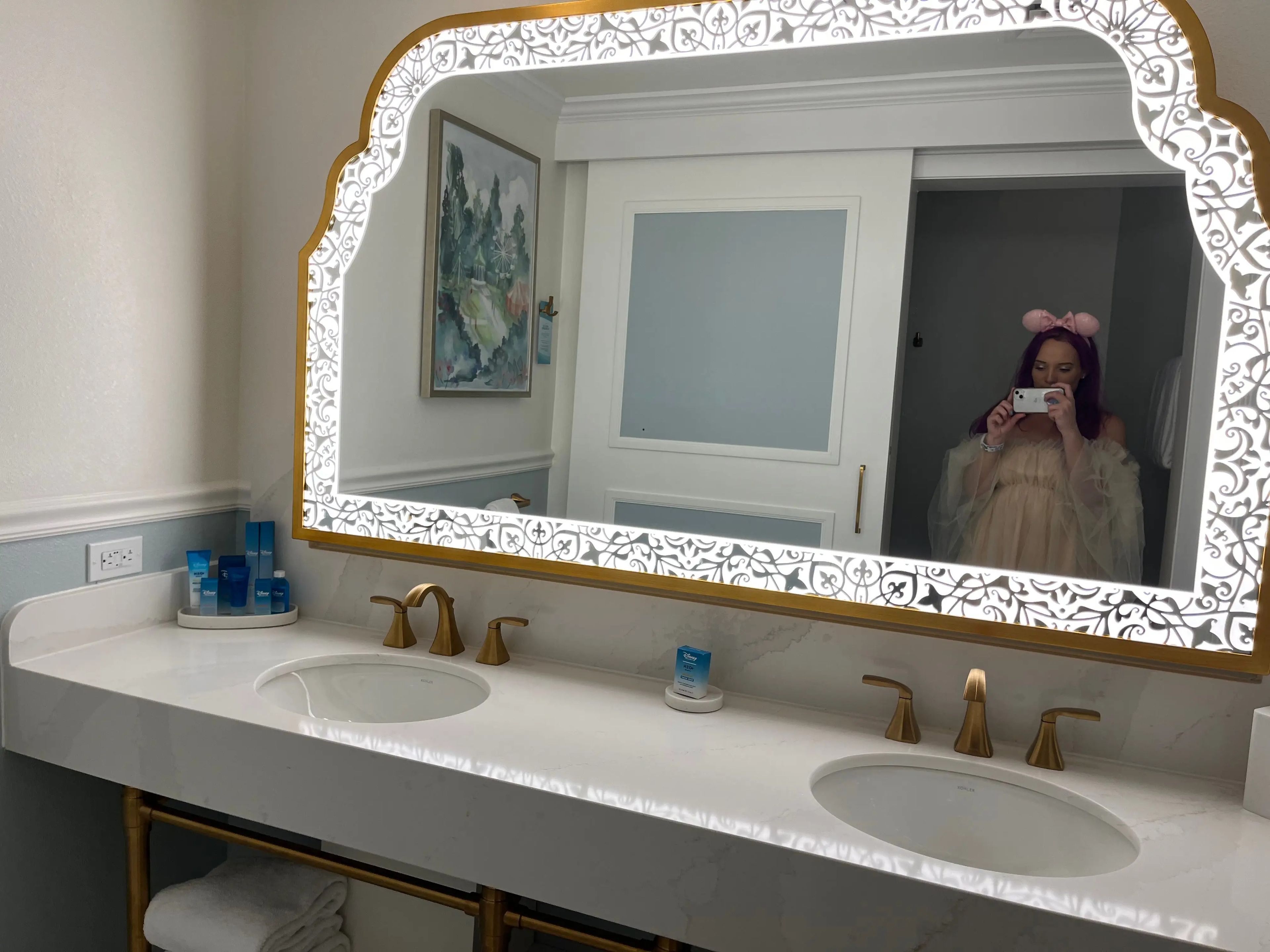 jenna taking a mirror selfie in the big double vanity in the bathroom inside a room at the grand floridian