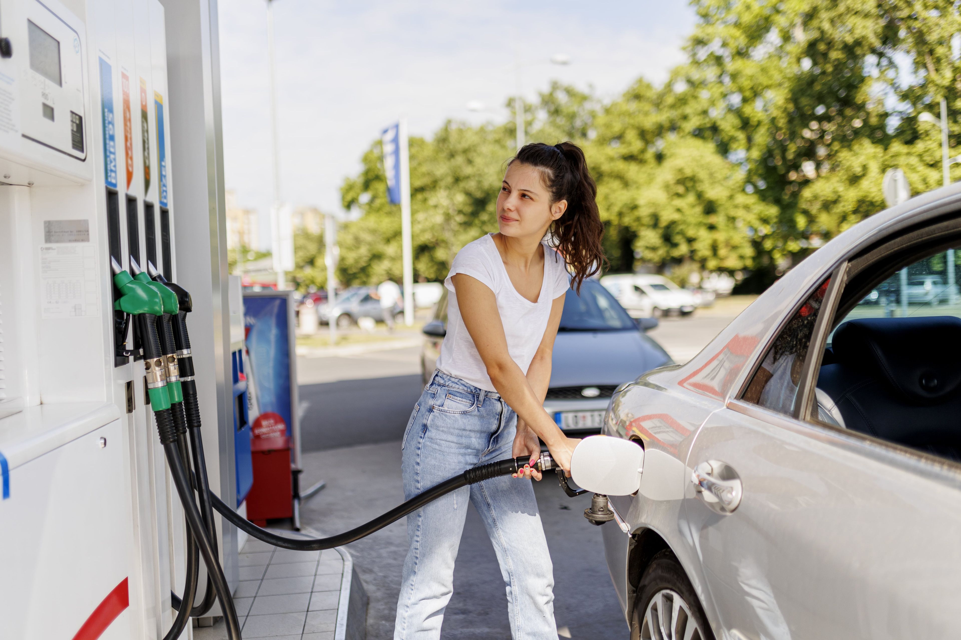 Mujer joven echando gasolina a su coche