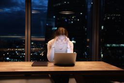 Mujer trabajadora cansada, en una oficina por la noche