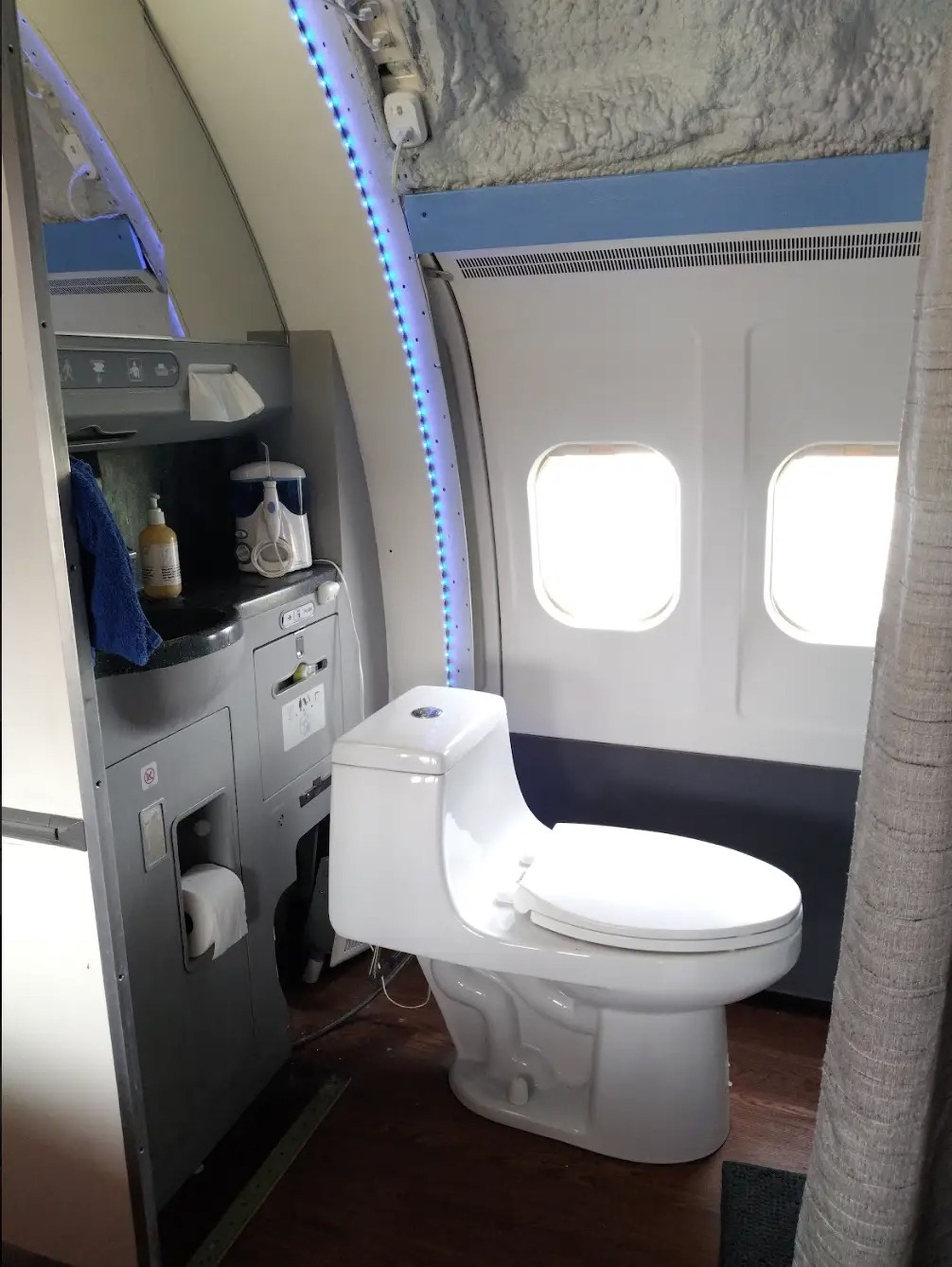 Original plane sink and vanity structure with a new toilet in the renovated Bed in the renovated MD-80.