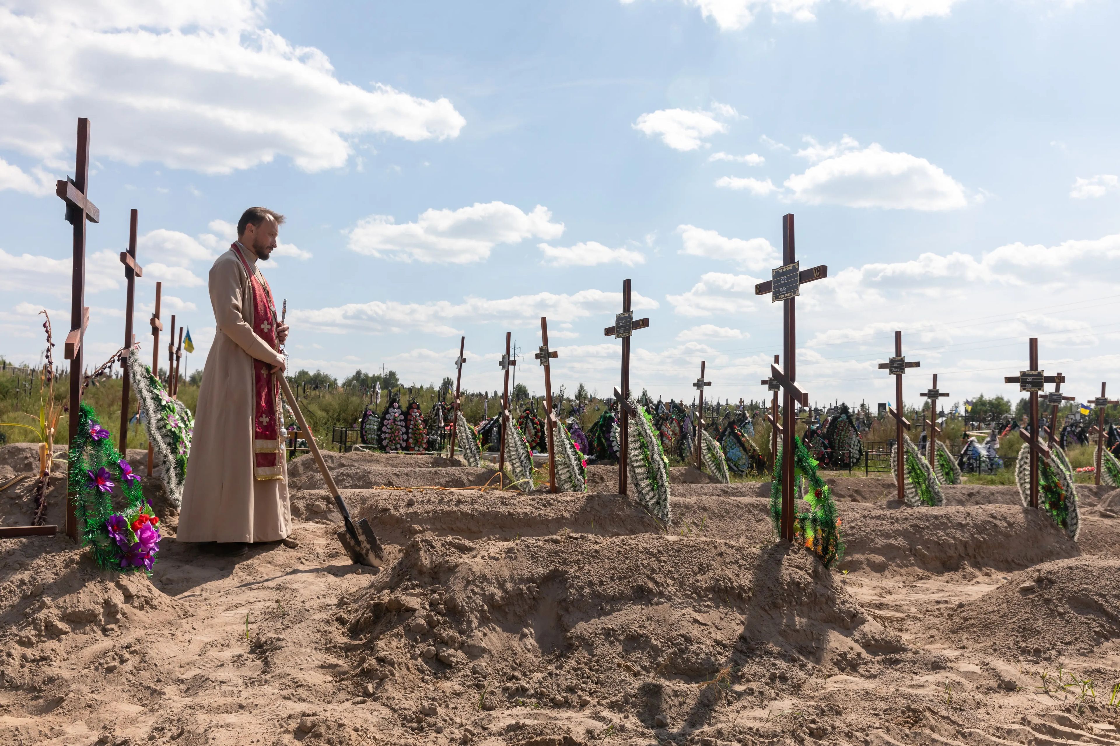 El sacerdote ortodoxo Andriy Galavin bendice los restos de los asesinados en Bucha, Ucrania, durante la ocupación rusa.