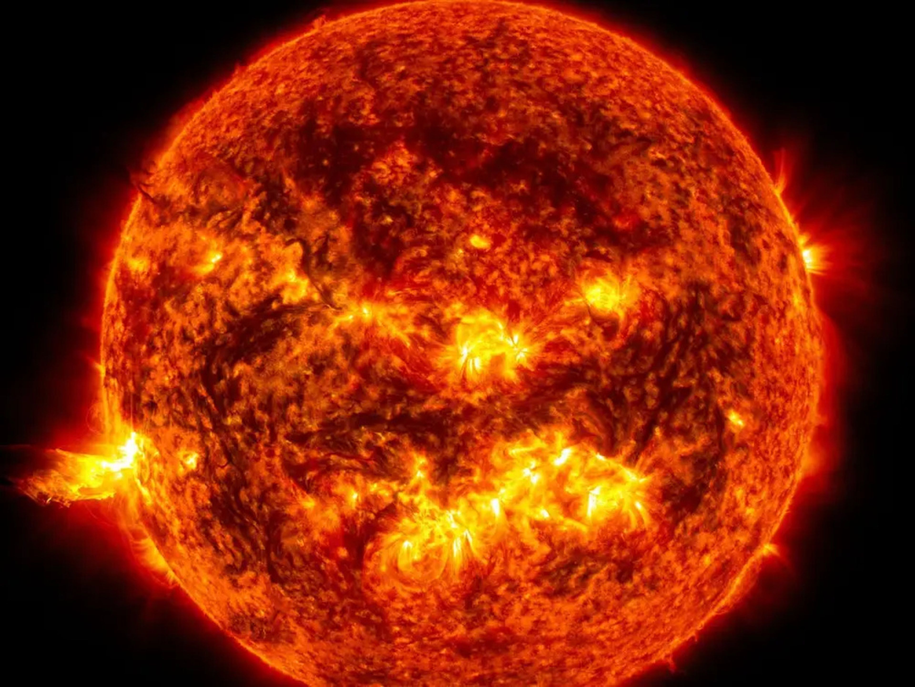 La luz brillante de una erupción solar en el lado izquierdo del sol en una imagen tomada en junio de 2013.