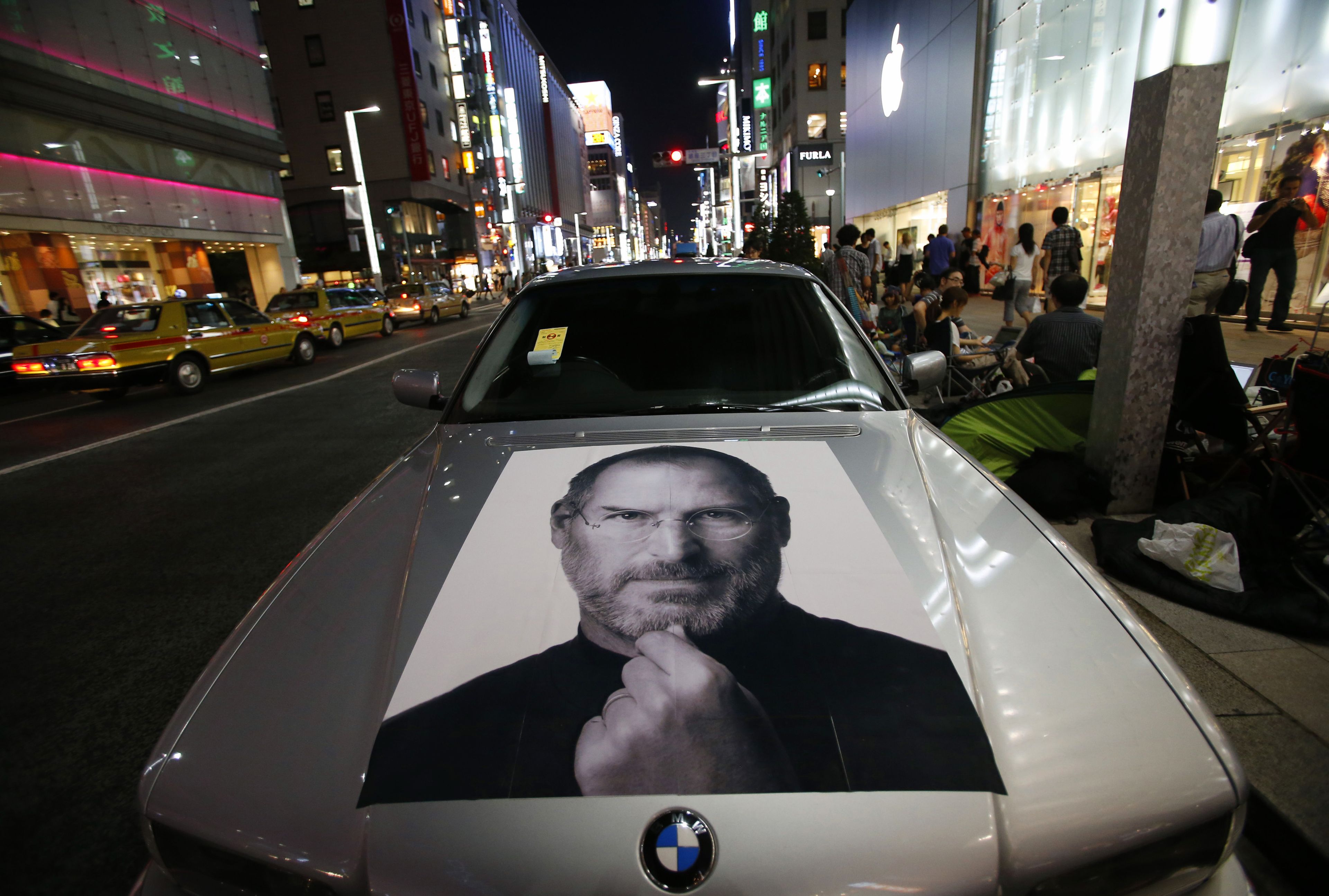 Retrato de Steve Jobs en un coche BMW, el día del lanzamiento del iPhone 5 frente a la Apple Store Ginza en Tokio (Japón), en 2012.
