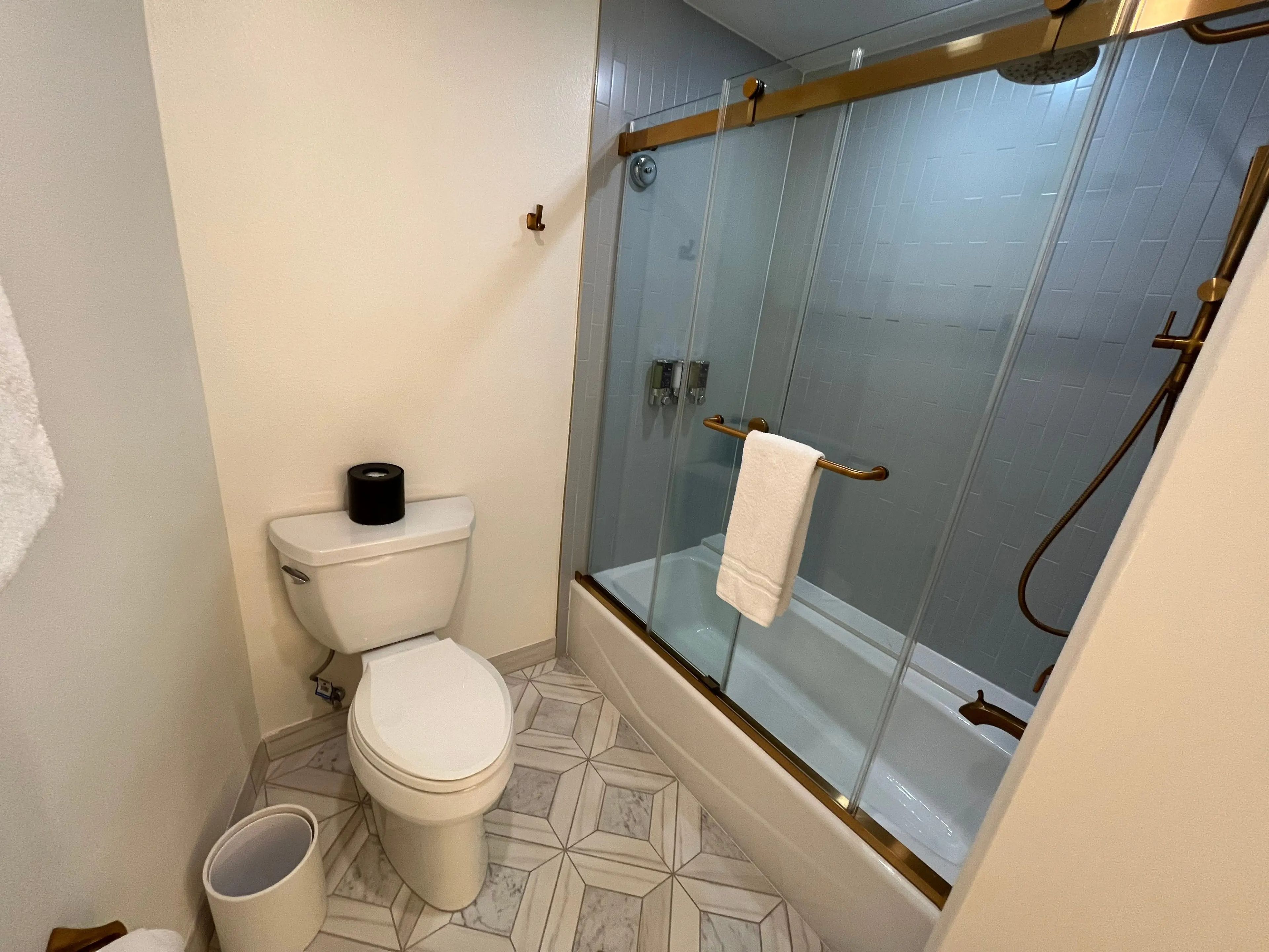 toilet and shower/tub with sliding door in the bathroom of a room at the grand floridian resort