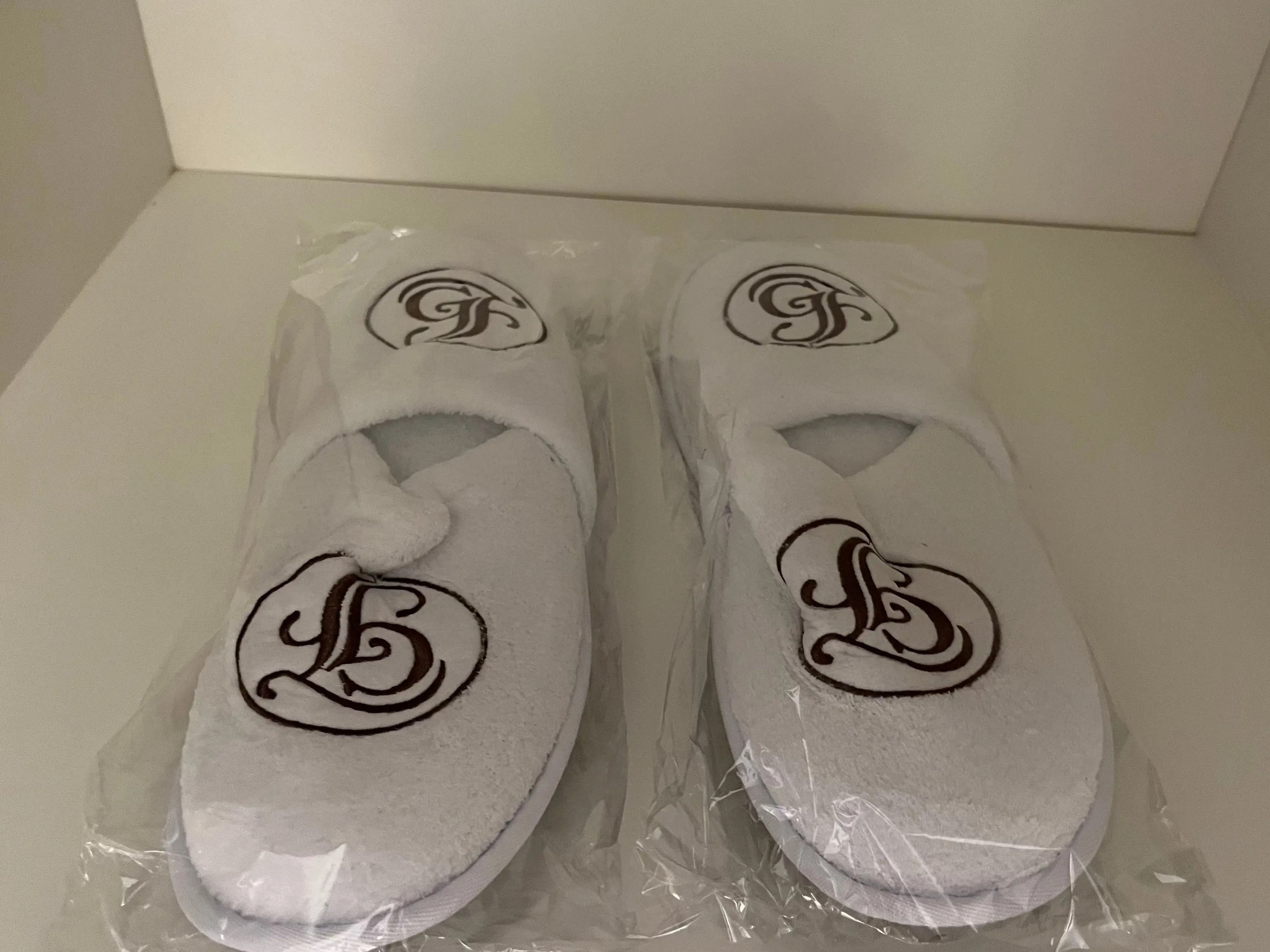 two pairs of white grand floridian slippers in plastic wrappings in a closet inside a room at the grand floridian resort