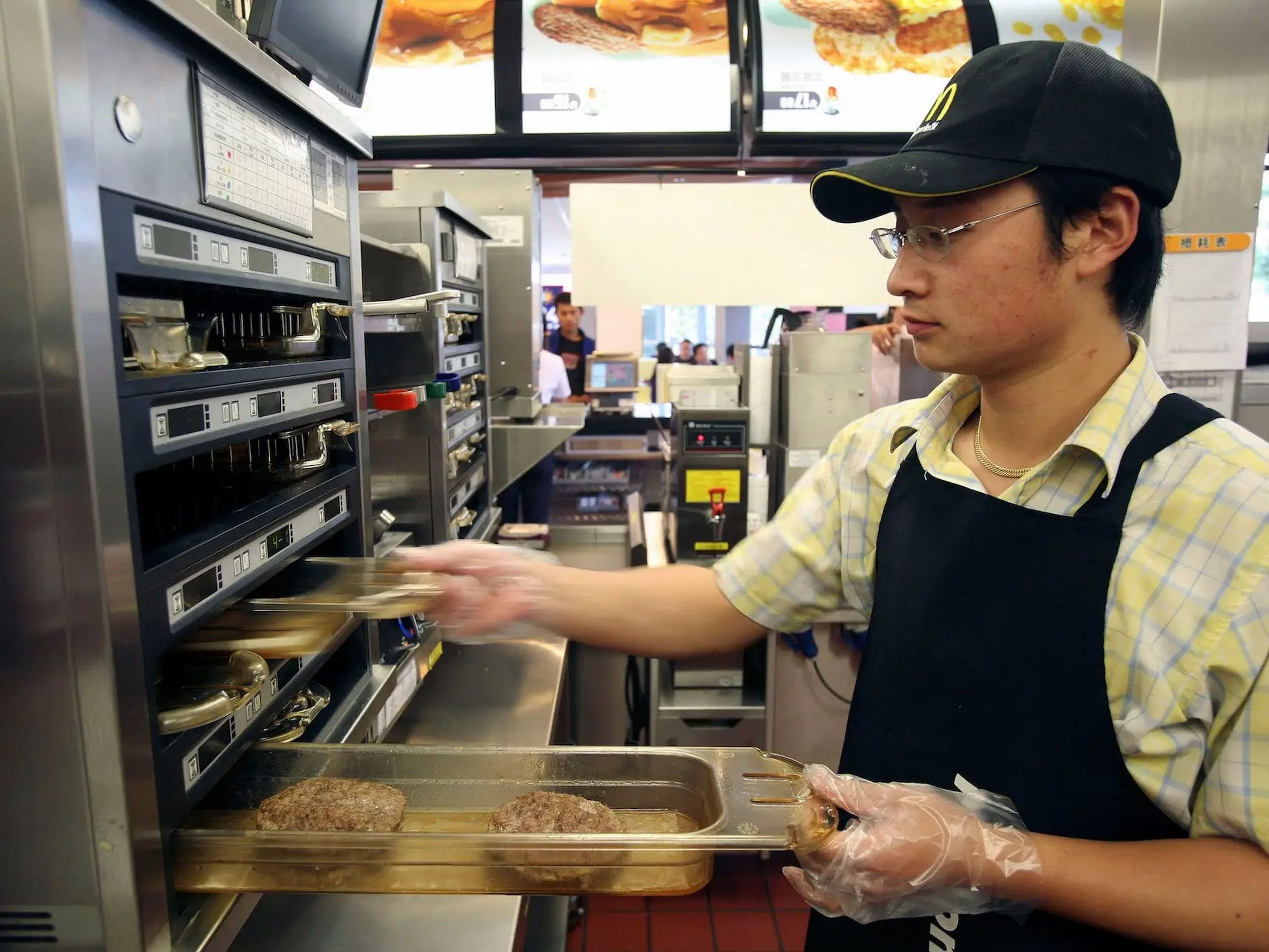 Un empleado de McDonald's preparando hamburguesas.