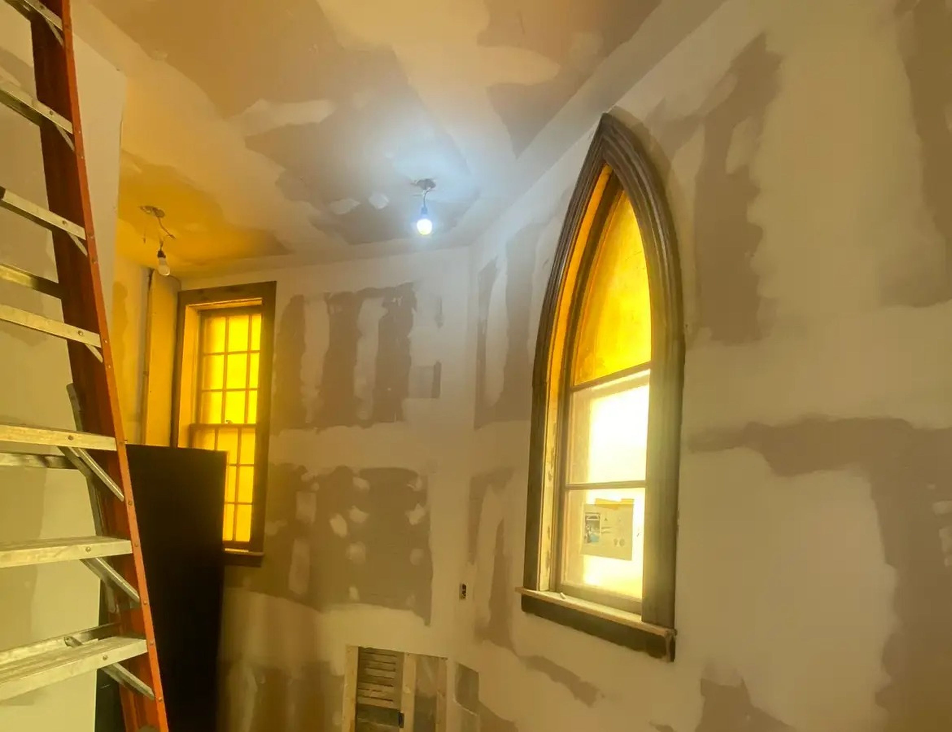 New drywall around a peaked window.
