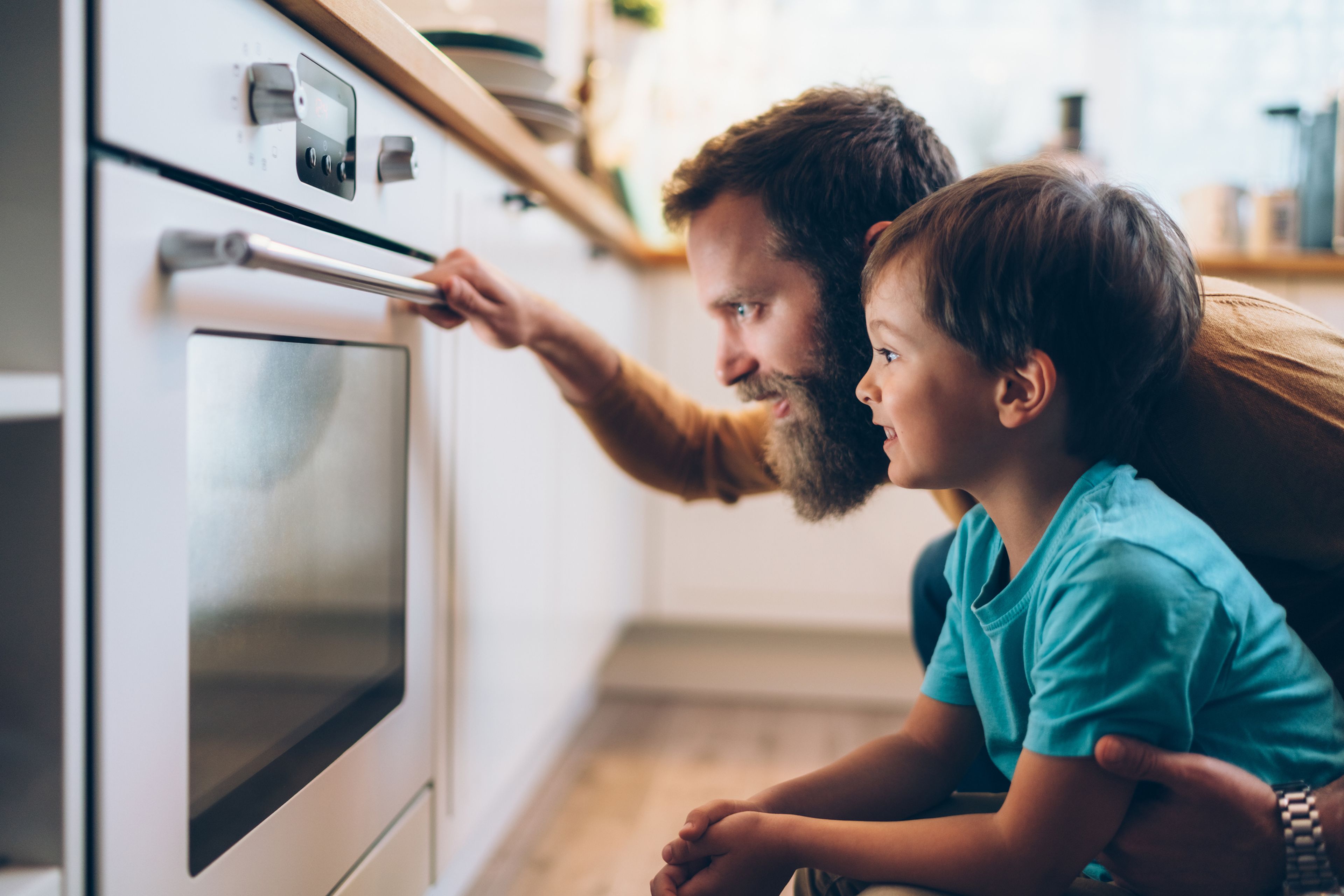 Un padre y su hijo poniendo el horno.