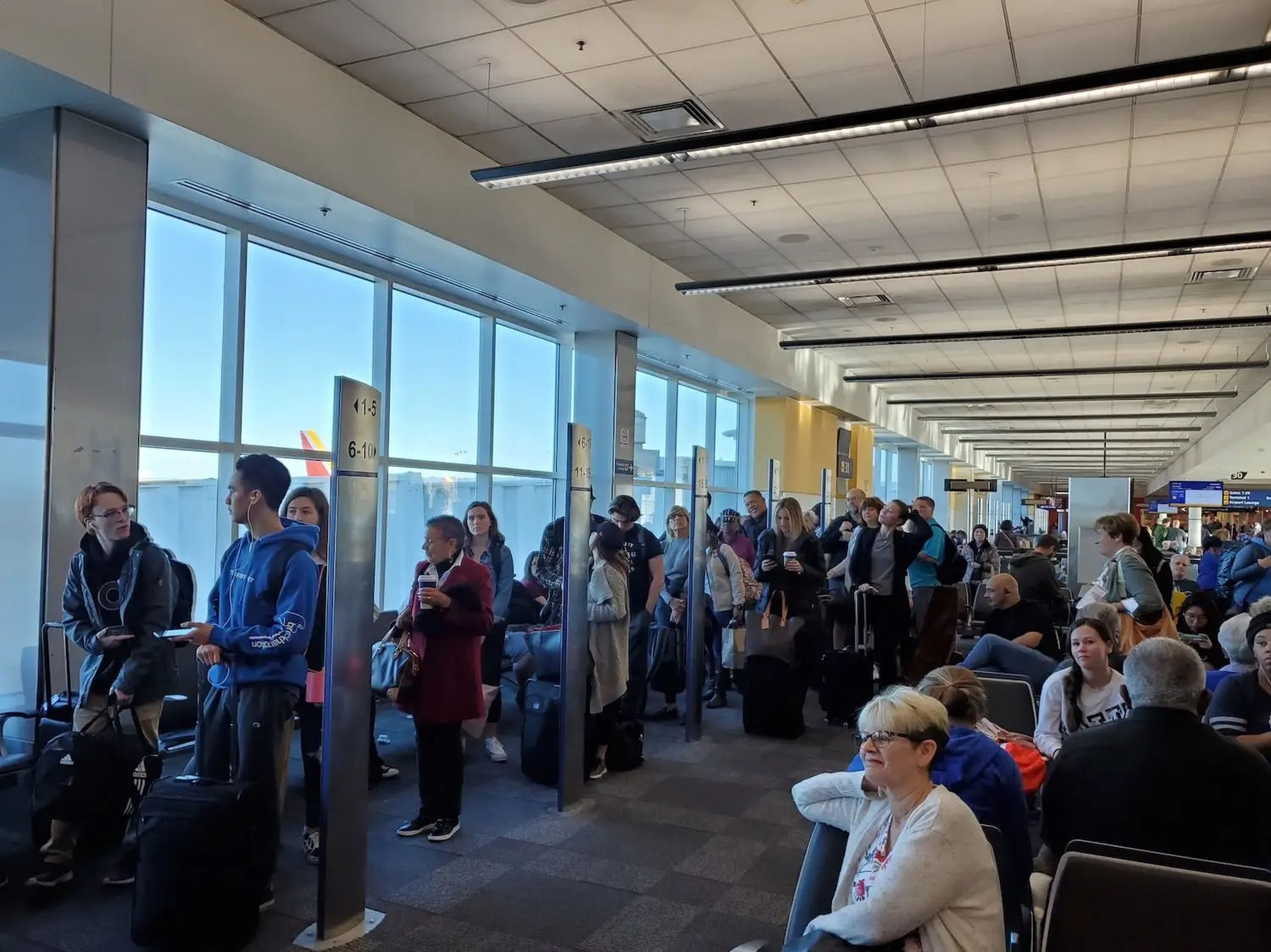 People line up based on boarding group numbers to board a Southwest Airlines flight.