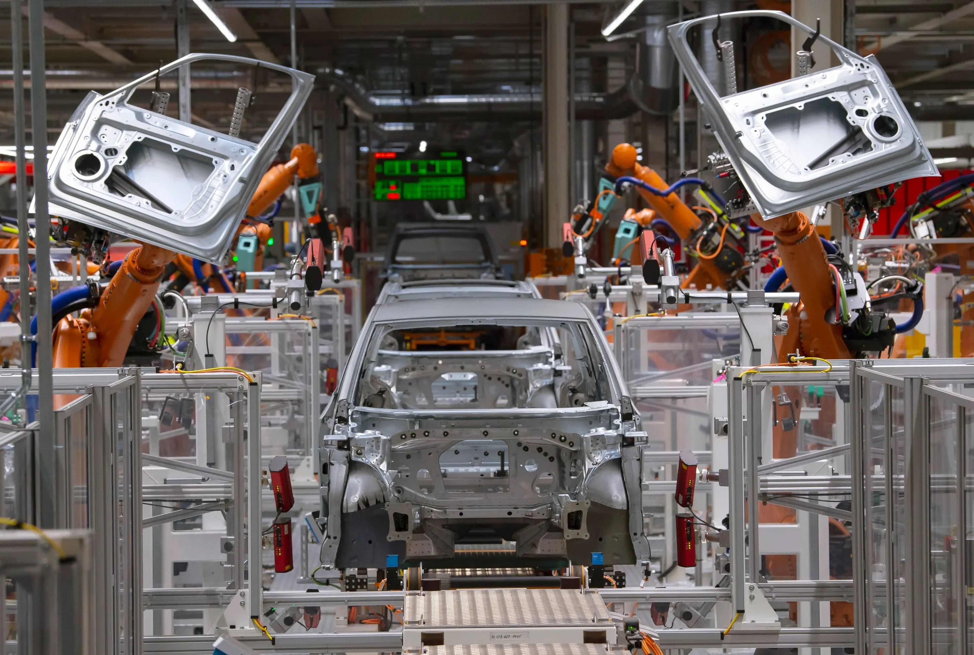 Unos robots ensamblando las piezas de un coche.
