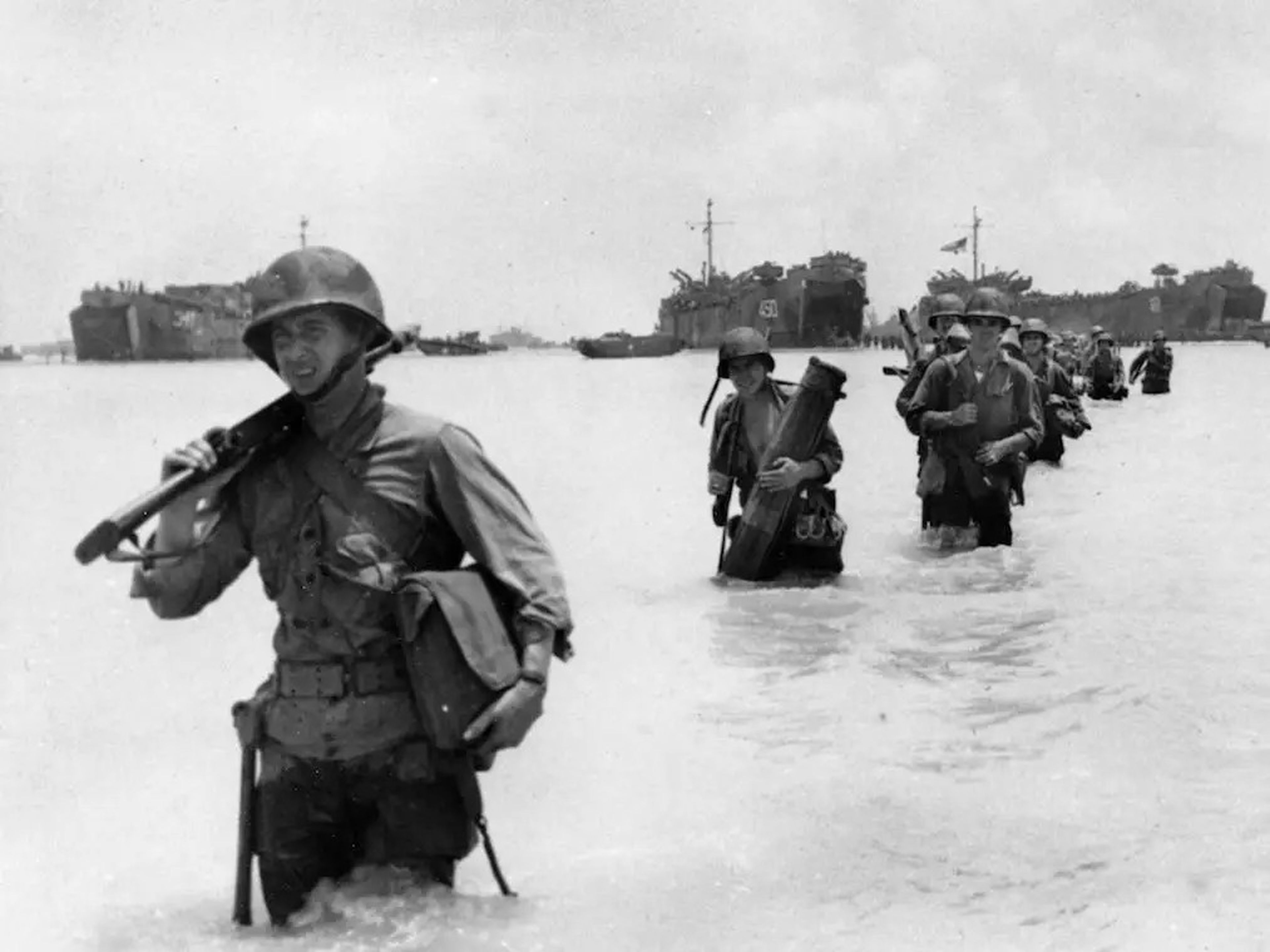 En junio de 1944, en Saipán, en las Islas Marianas, a unas 1.500 millas de Japón, refuerzos del ejército estadounidense desembarcan desde los tanques de los buques situados al fondo.
