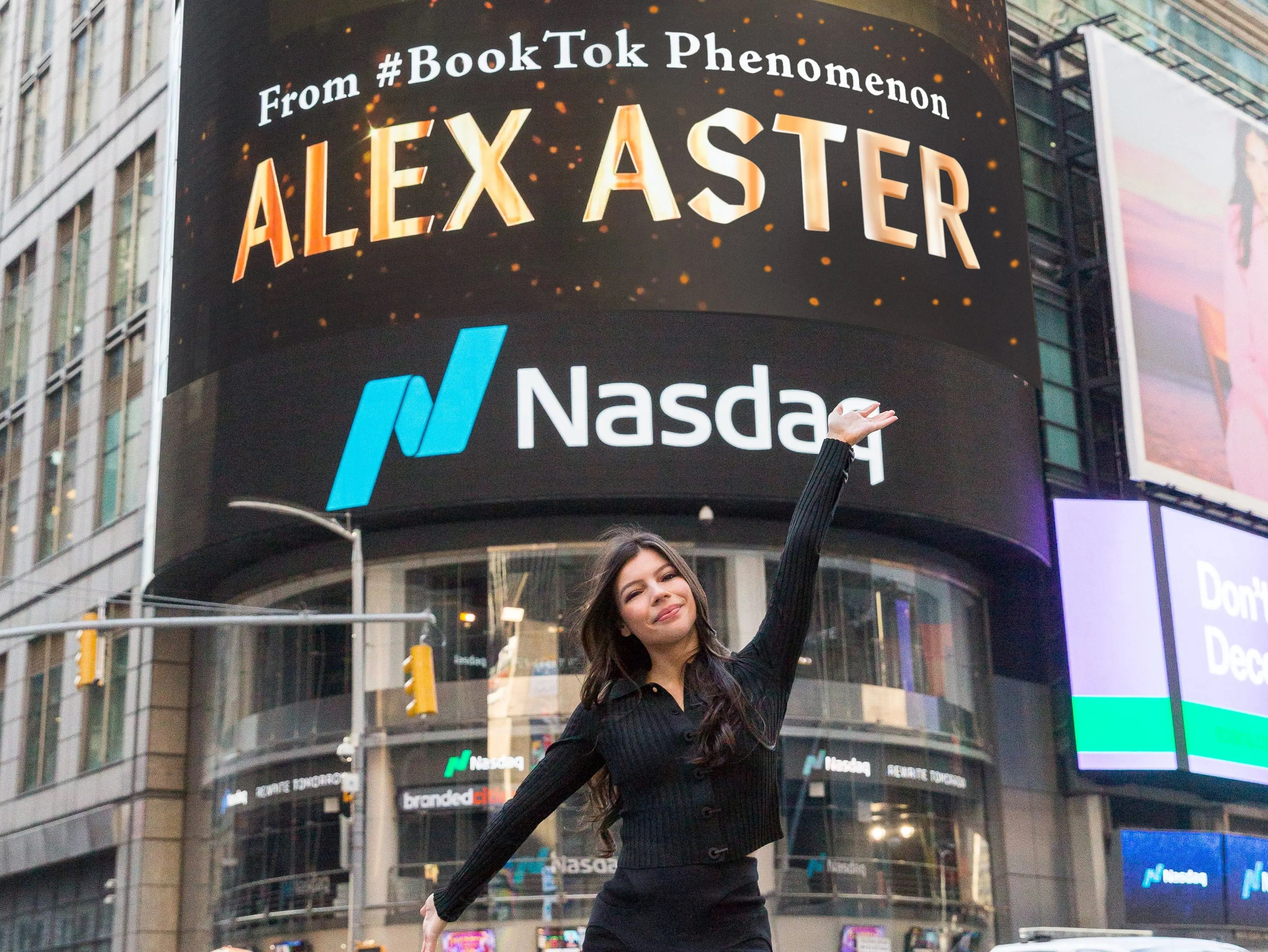 Alex Aster delante de una valla publicitaria en Times Square que muestra la portada de su libro 'Lightlark'.