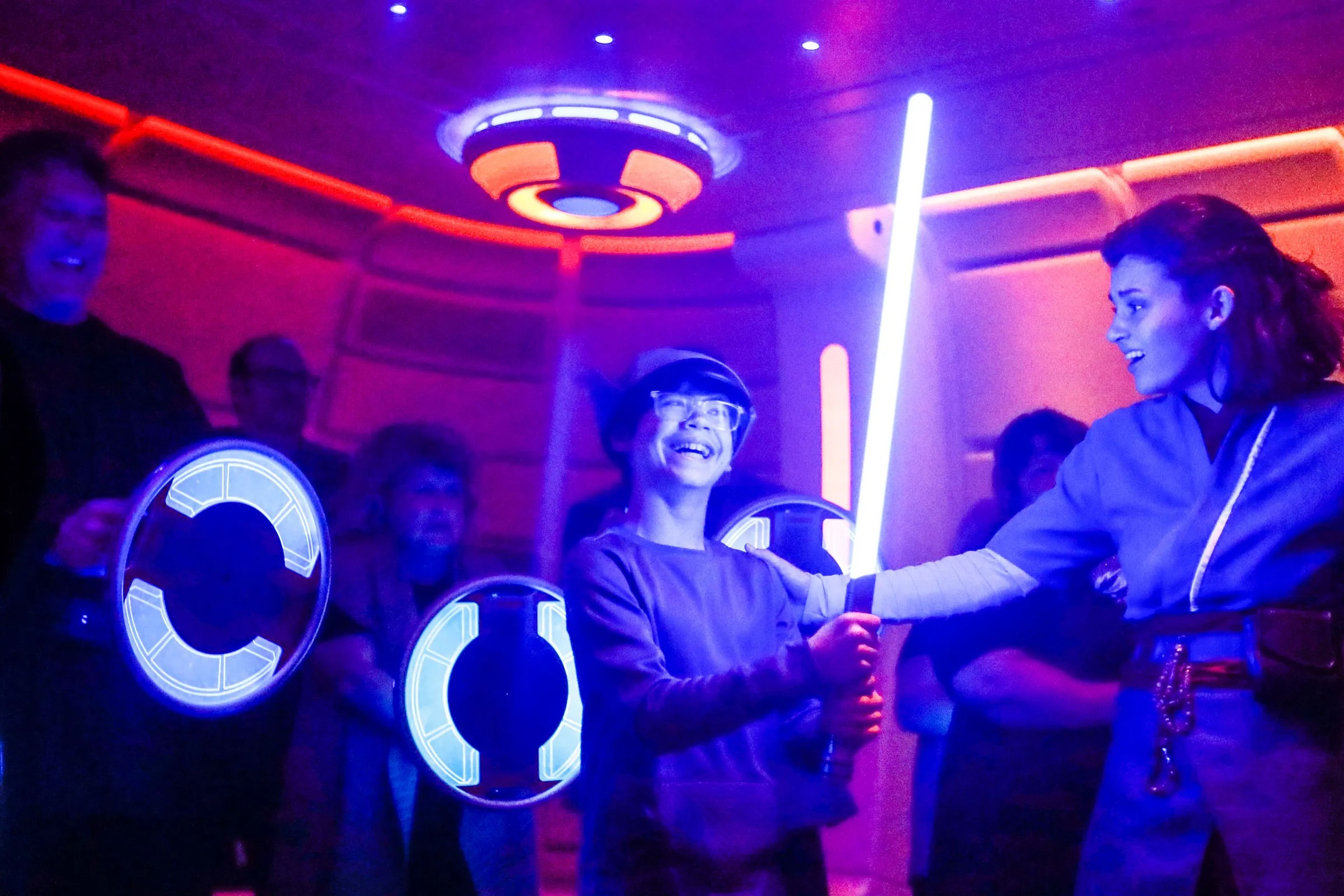 A child holds a lightsaber at the Star Wars: Galactic Starcruiser hotel