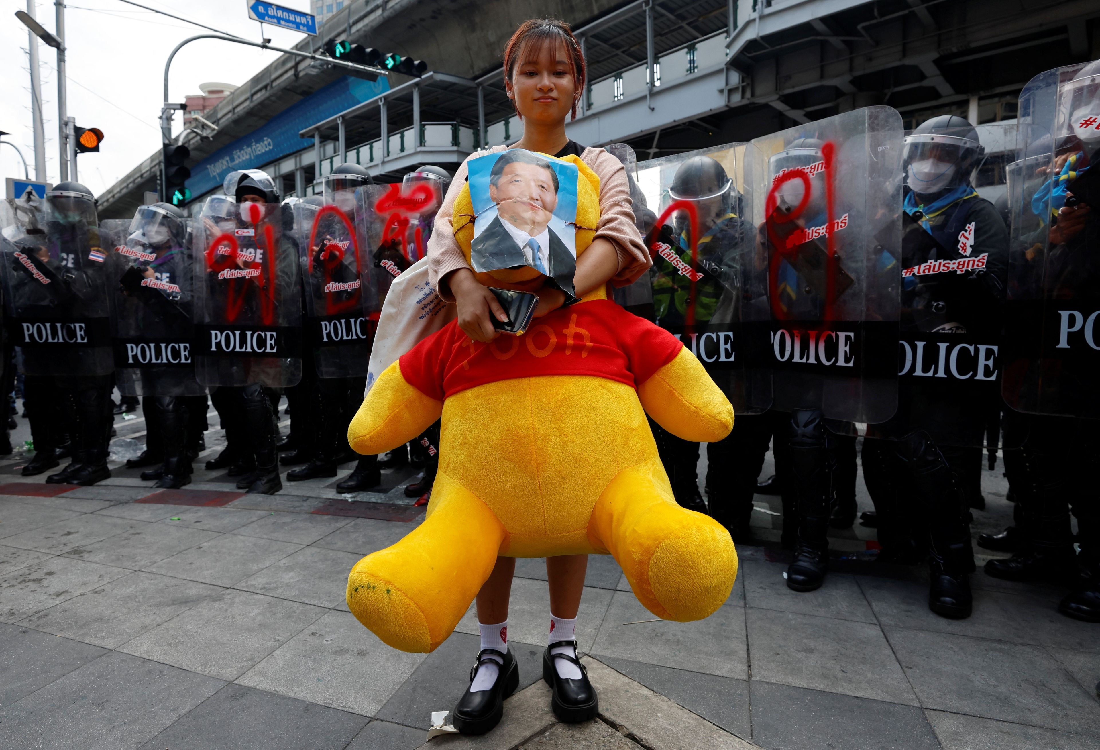 Un manifestante lleva un oso Winnie the Pooh con un retrato del presidente chino, Xi Jinping.
