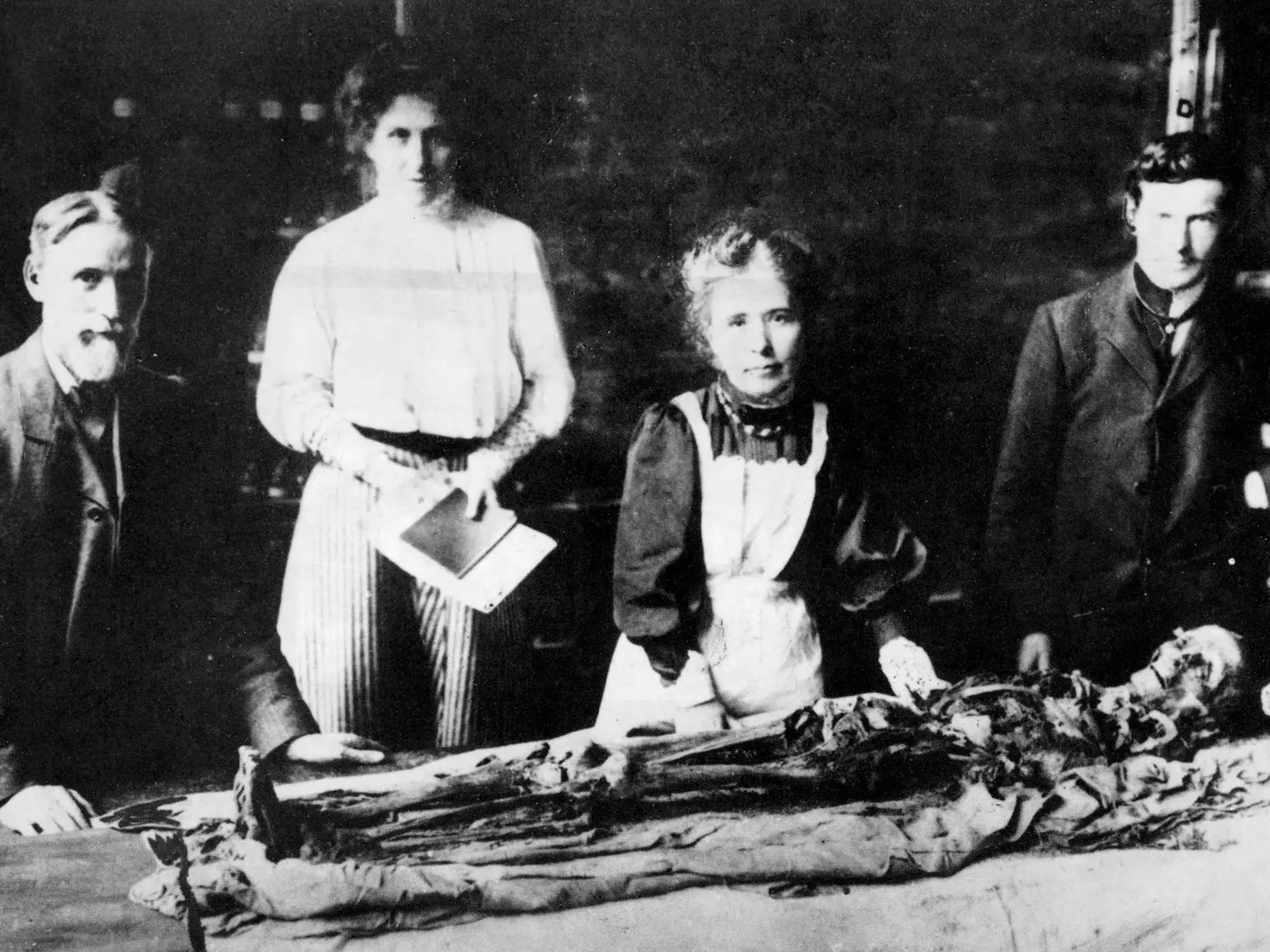 Fotografía monocroma de 1898 que muestra la última momia británica desenvuelta en condiciones científicas, en la Universidad de Manchester, dirigida por la Dra. Murray (3ª a la izquierda), la primera egiptóloga, y su ayudante Winnifred Crompton.