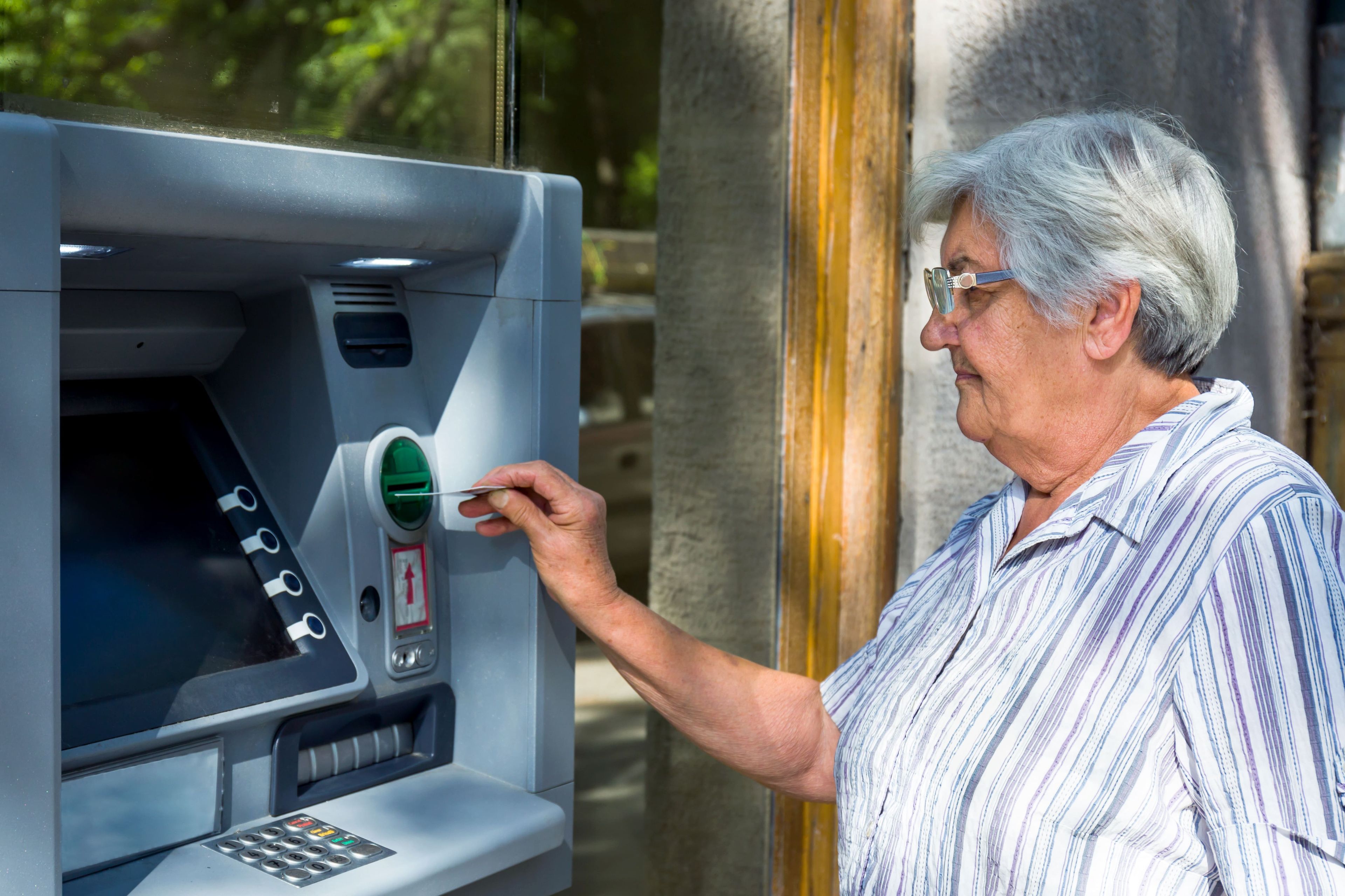 Mujer mayor sacando dinero del cajero