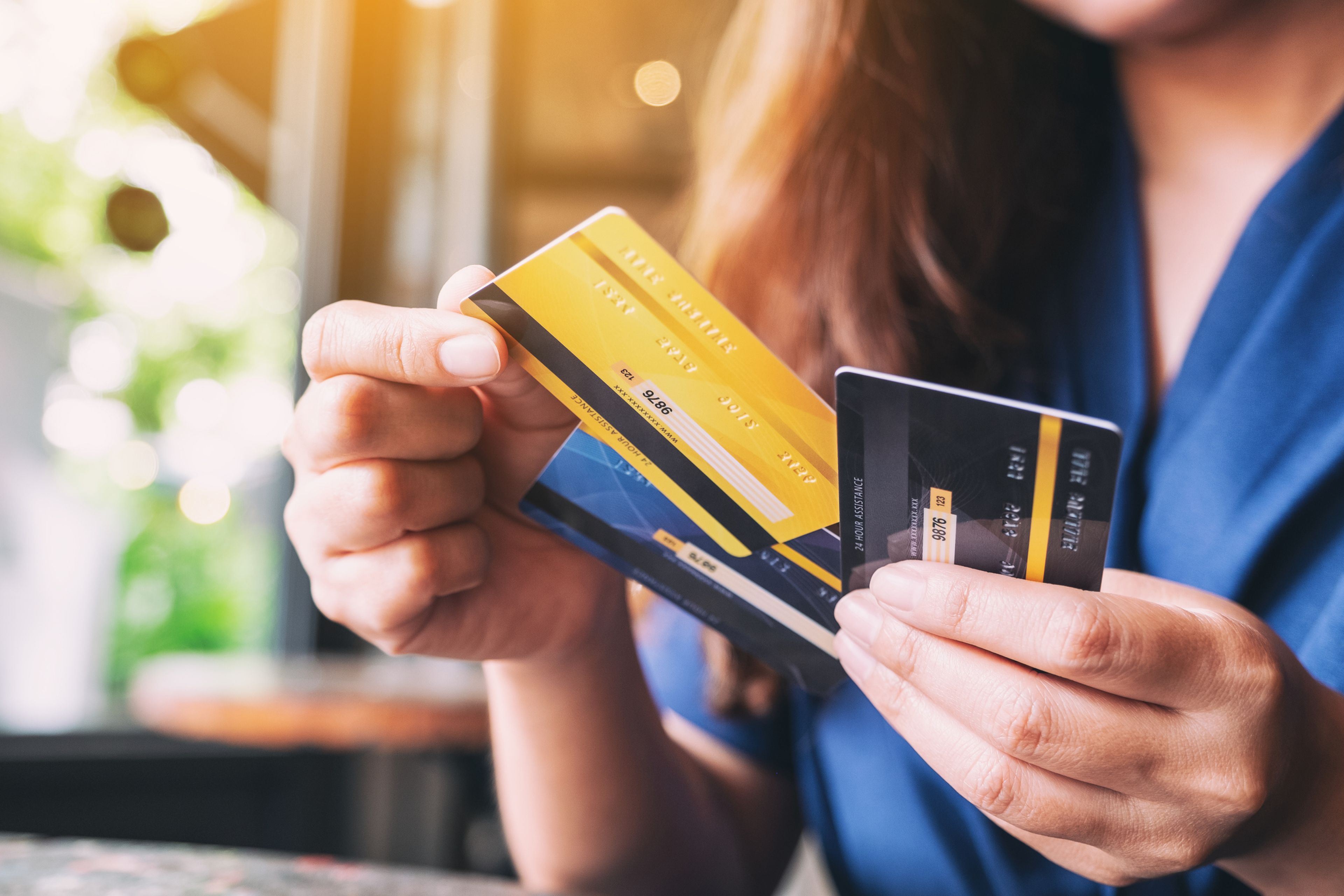 Una mujer muestra varias tarjetas de crédito/débito bancarias