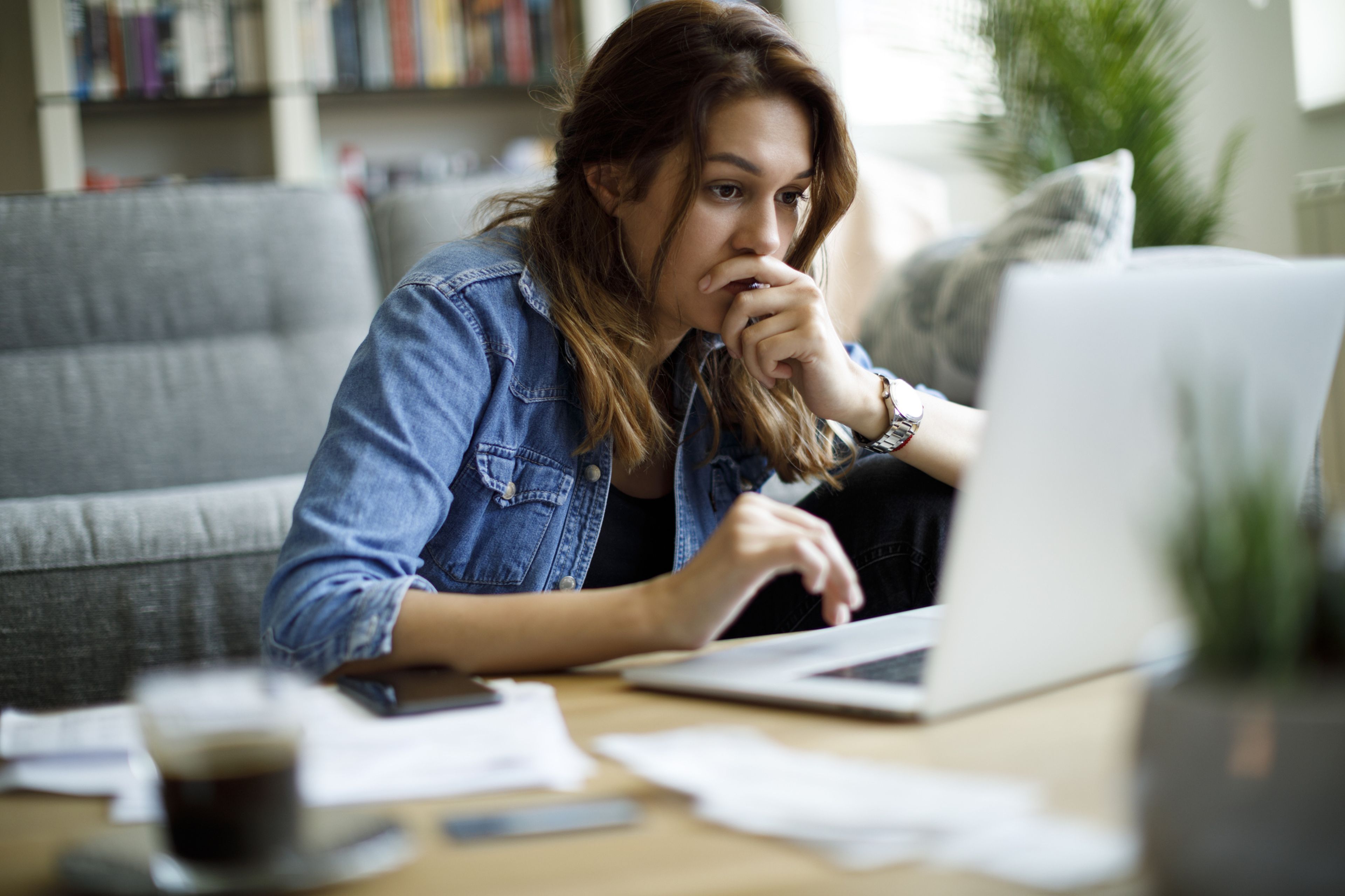 Mujer con ordenador en casa, concentrada