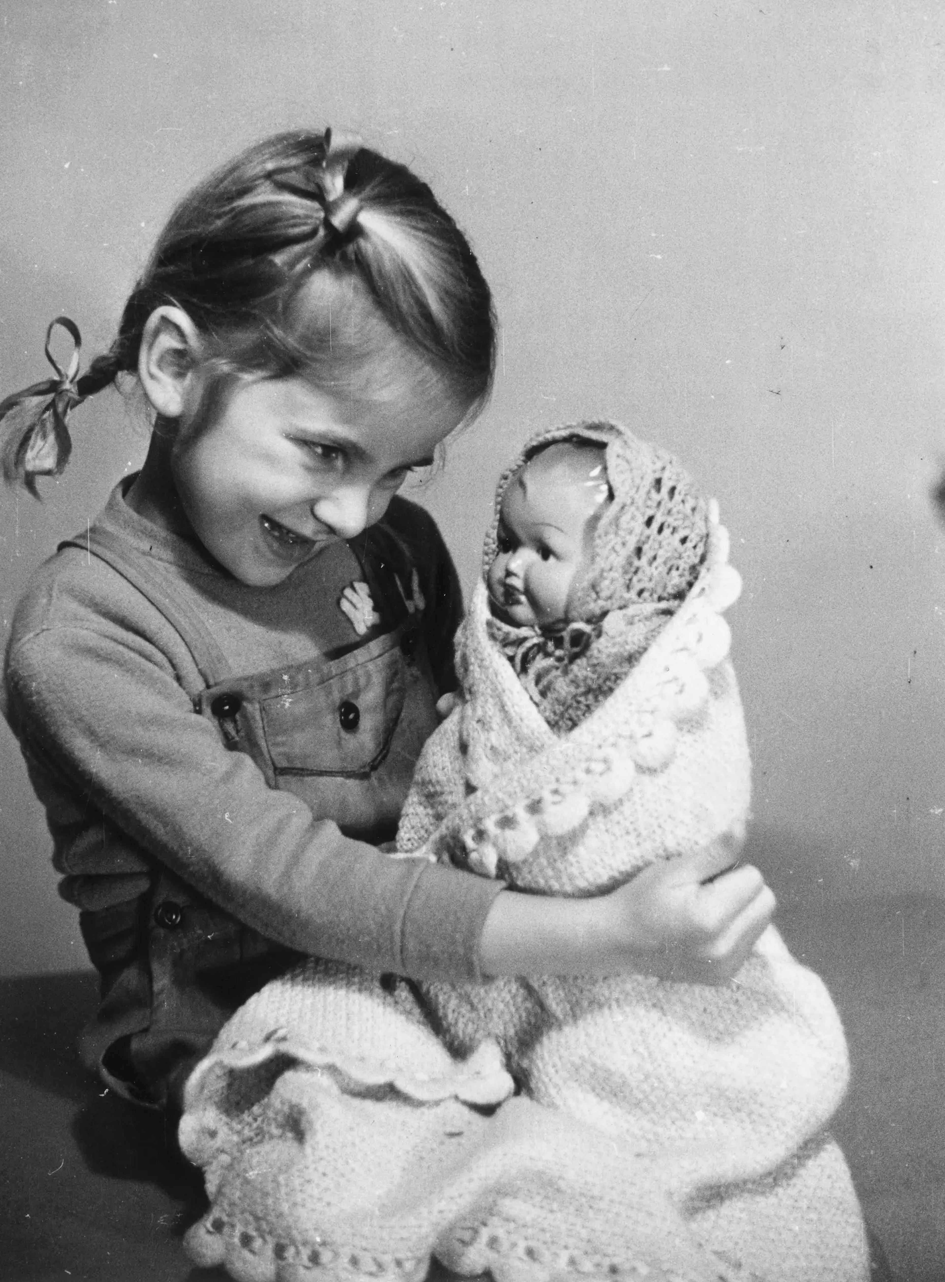 Una niña jugando con una muñeca en 1950.
