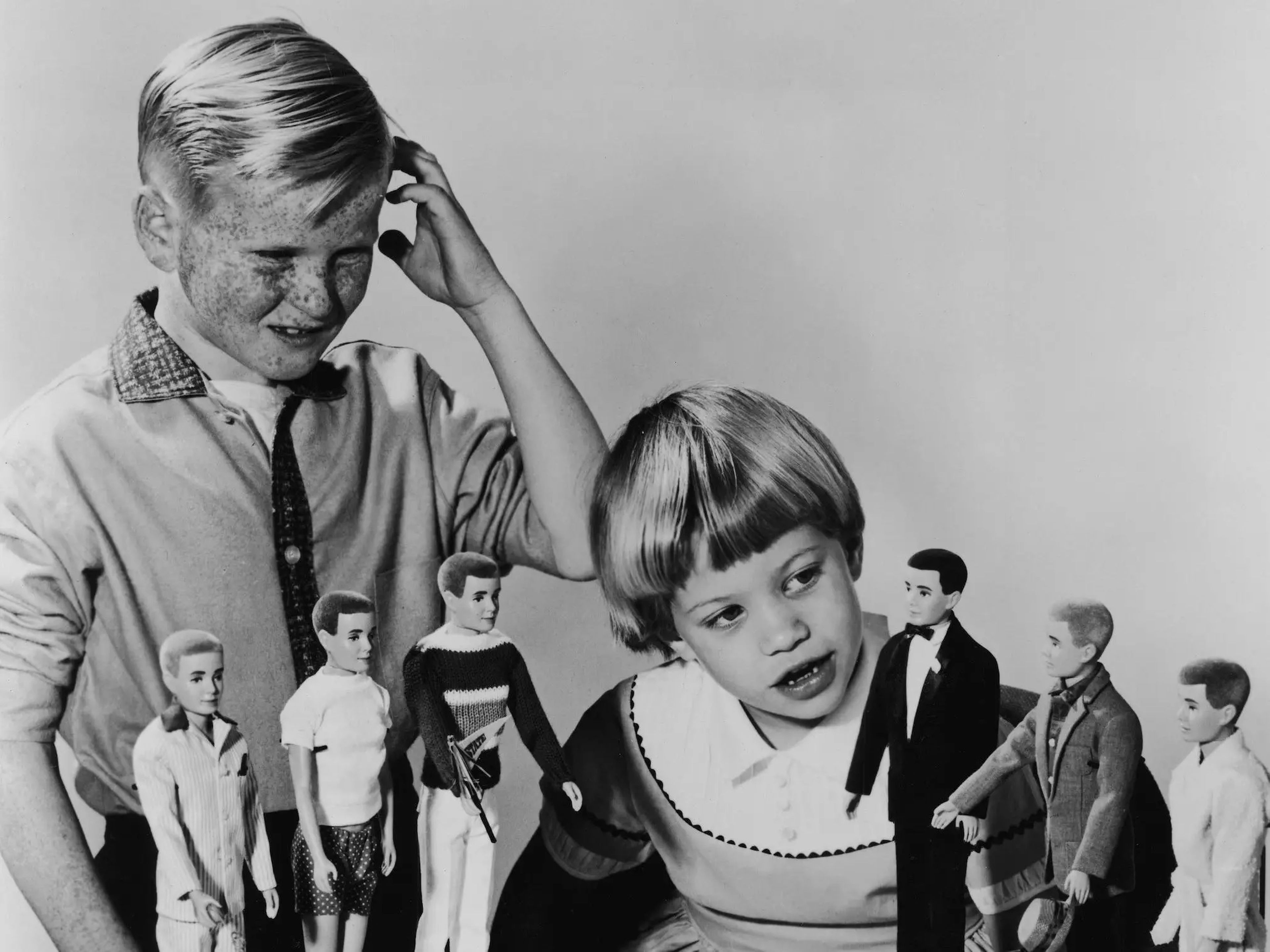 El niño se muestra confuso mientras una niña mira los muñecos Ken en 1961.