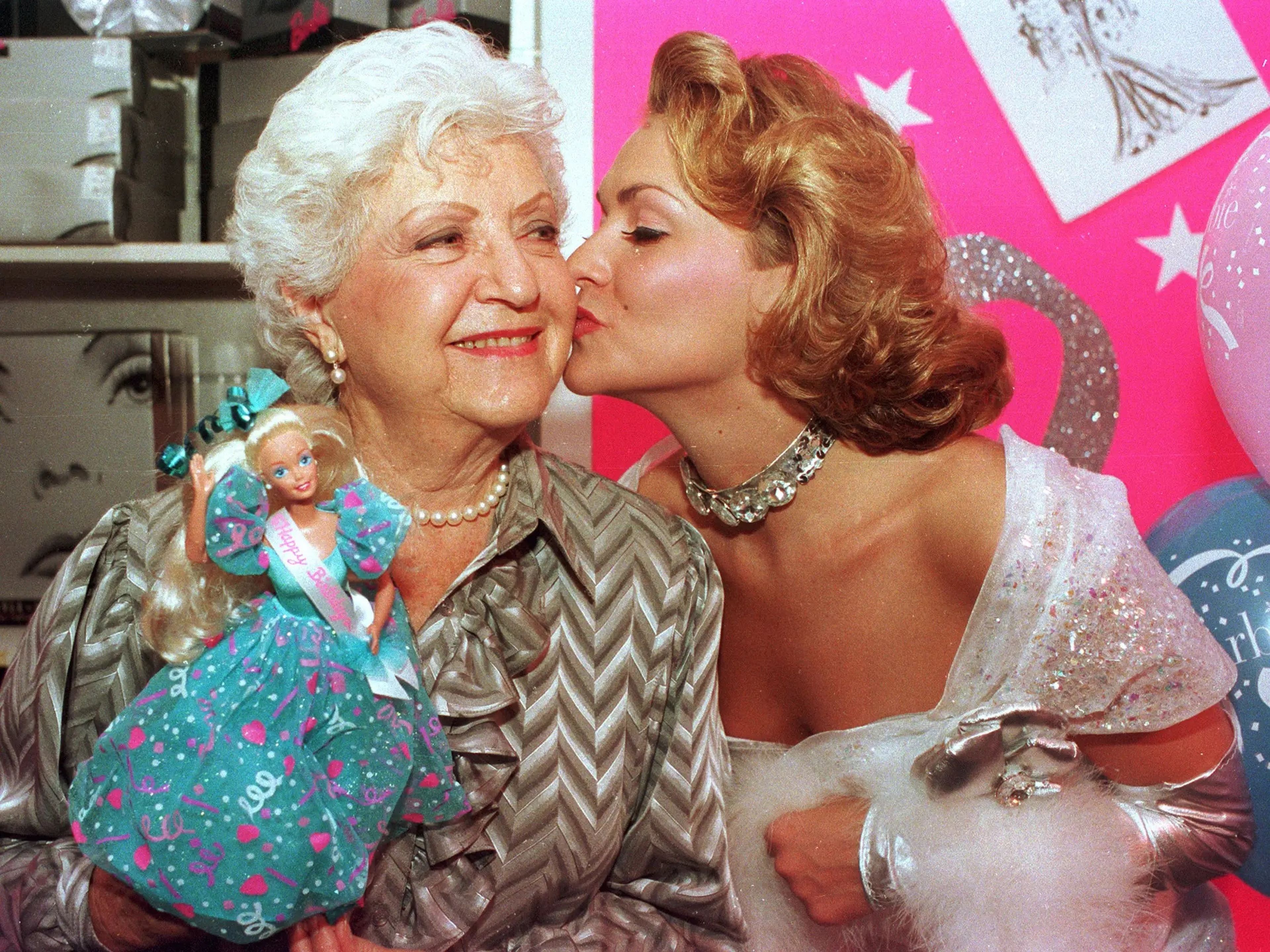 Ruth Handler recibiendo un beso de la actriz Kristi Cooke vestida de muñeca Barbie durante el 35 aniversario de la muñeca en Nueva York en 1994.
