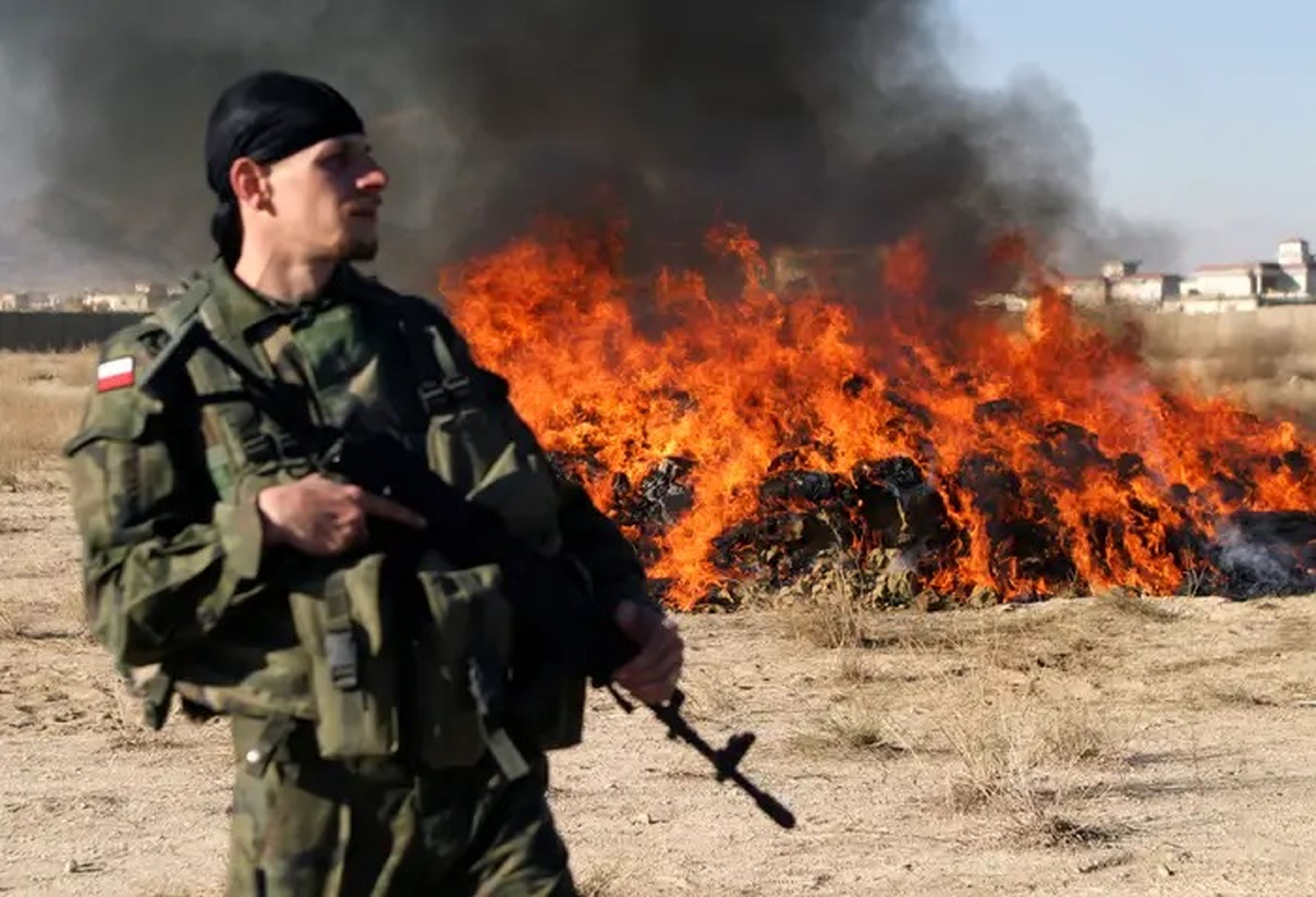 Un soldado polaco monta guardia ante una pila de narcóticos ilegales en llamas en la provincia afgana de Ghazni, 25 de noviembre de 2008.