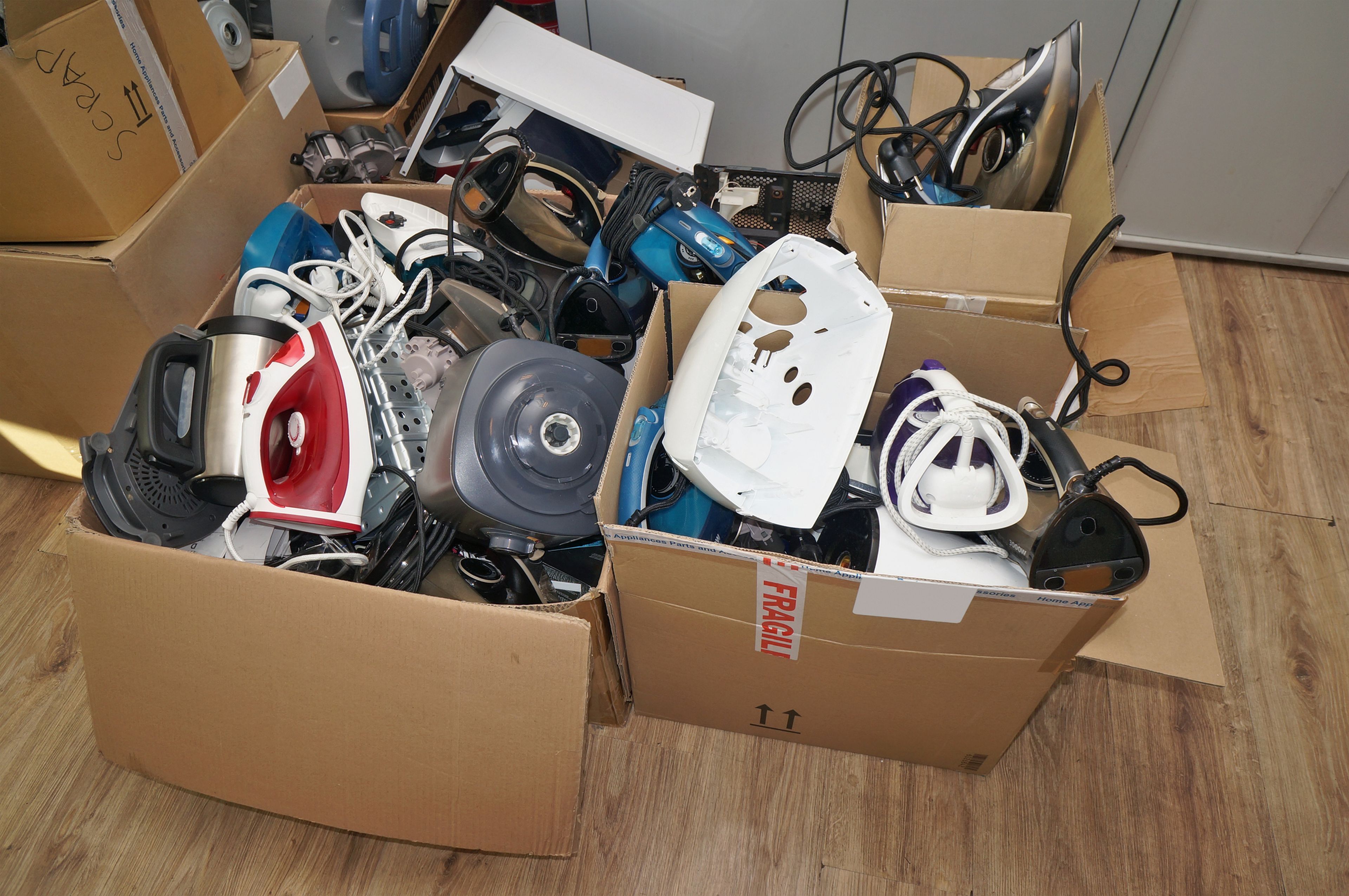 Varias cajas con aparatos electrónicos usados. 