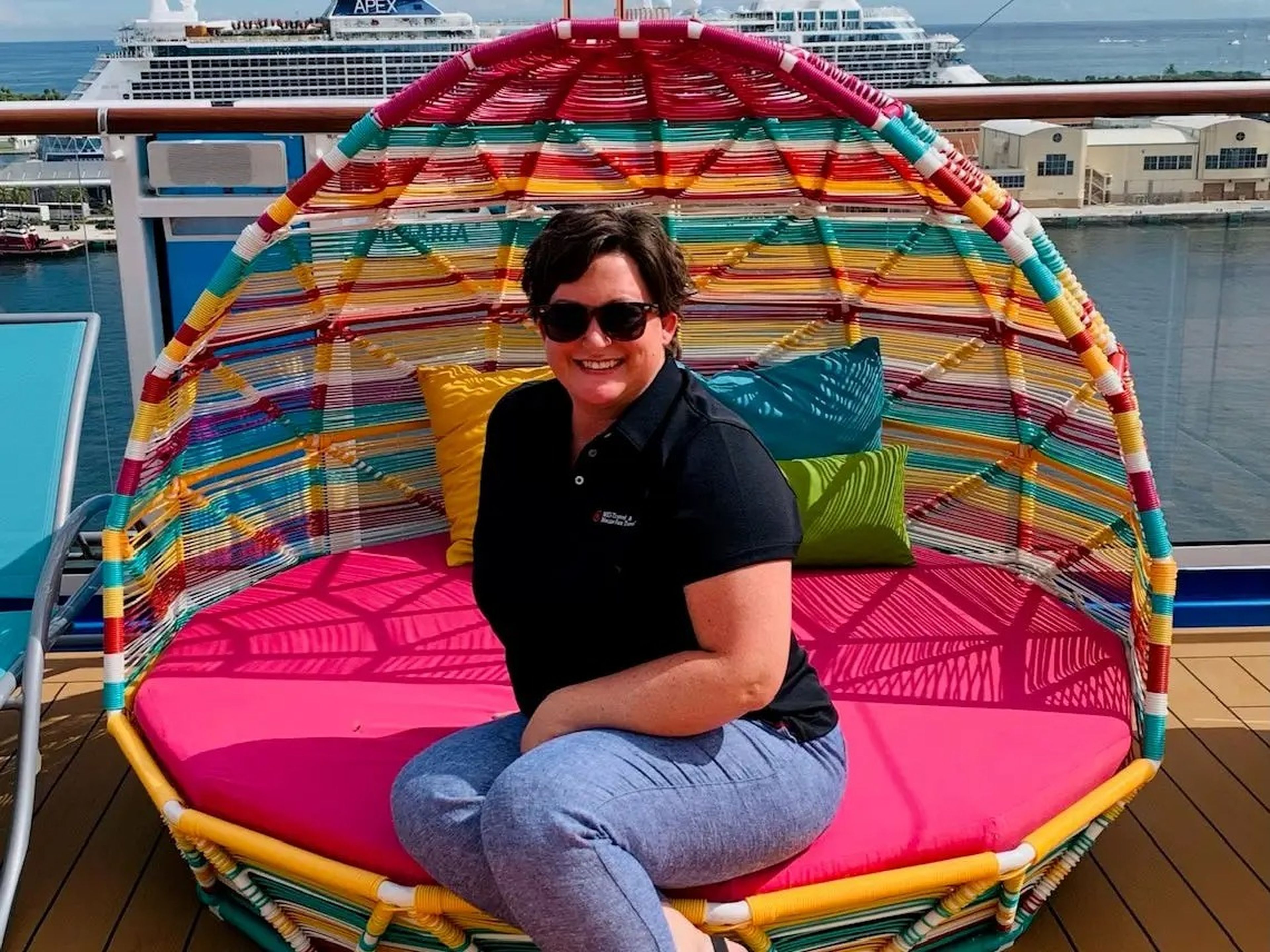 jennifer greene sitting in a colorful chair on a cruise deck