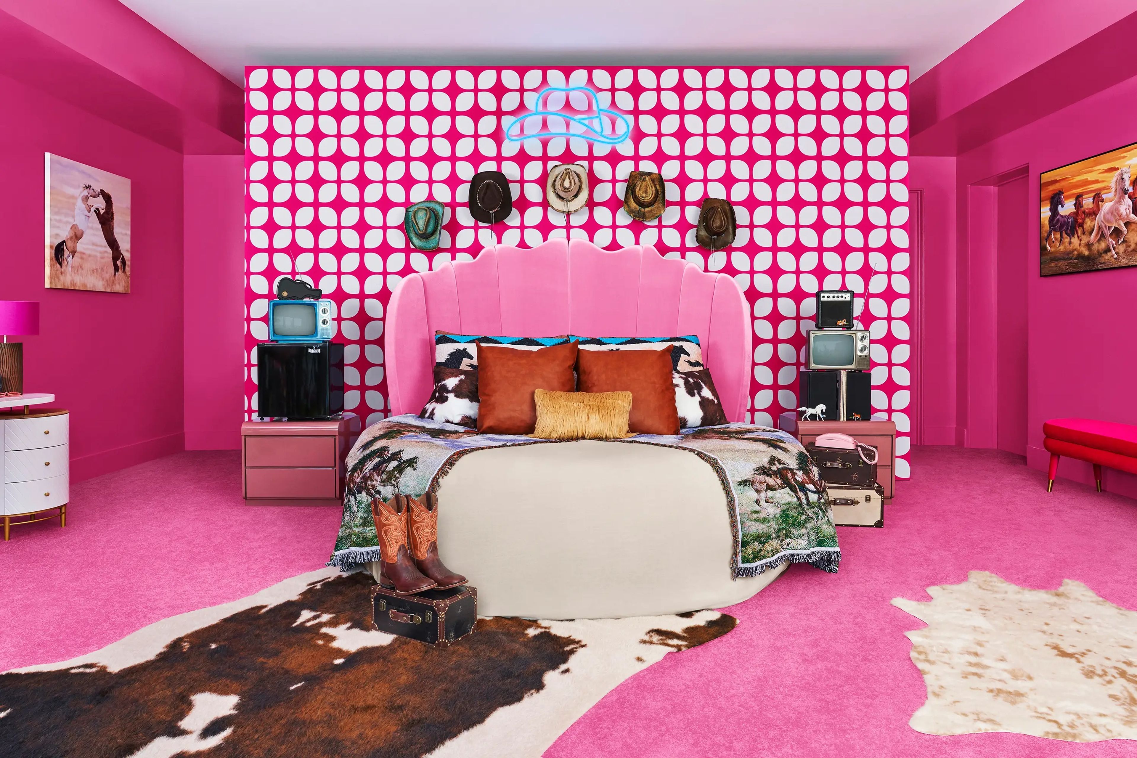 The master bedroom comes with hot pink floors and walls. Cowboy hats line the walls as part of the decor.