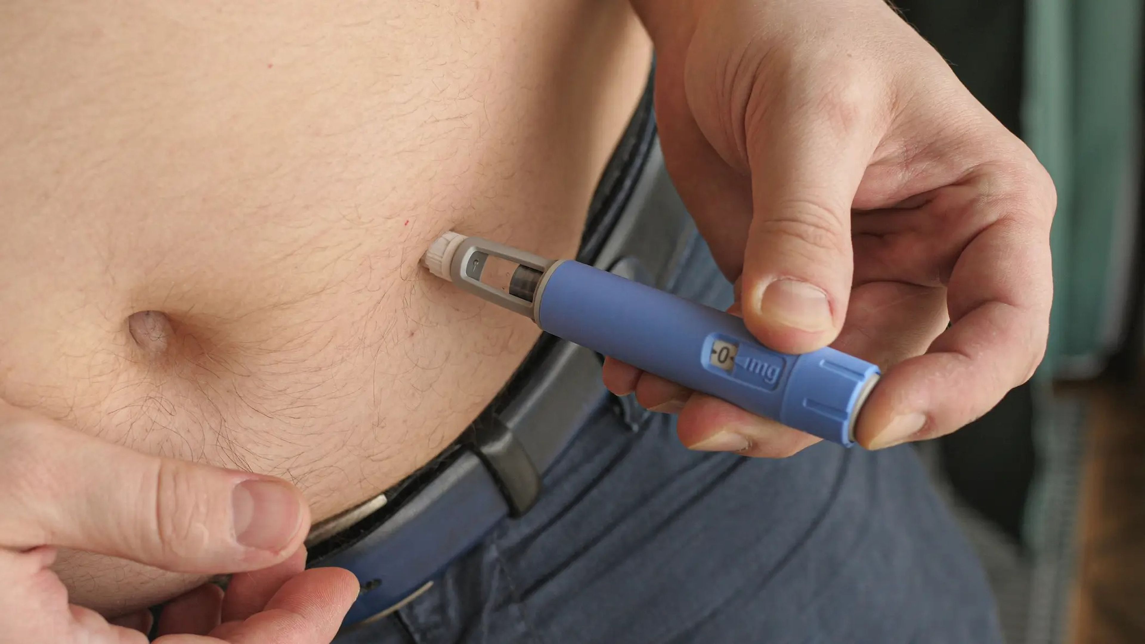 person injecting semaglutide into their belly