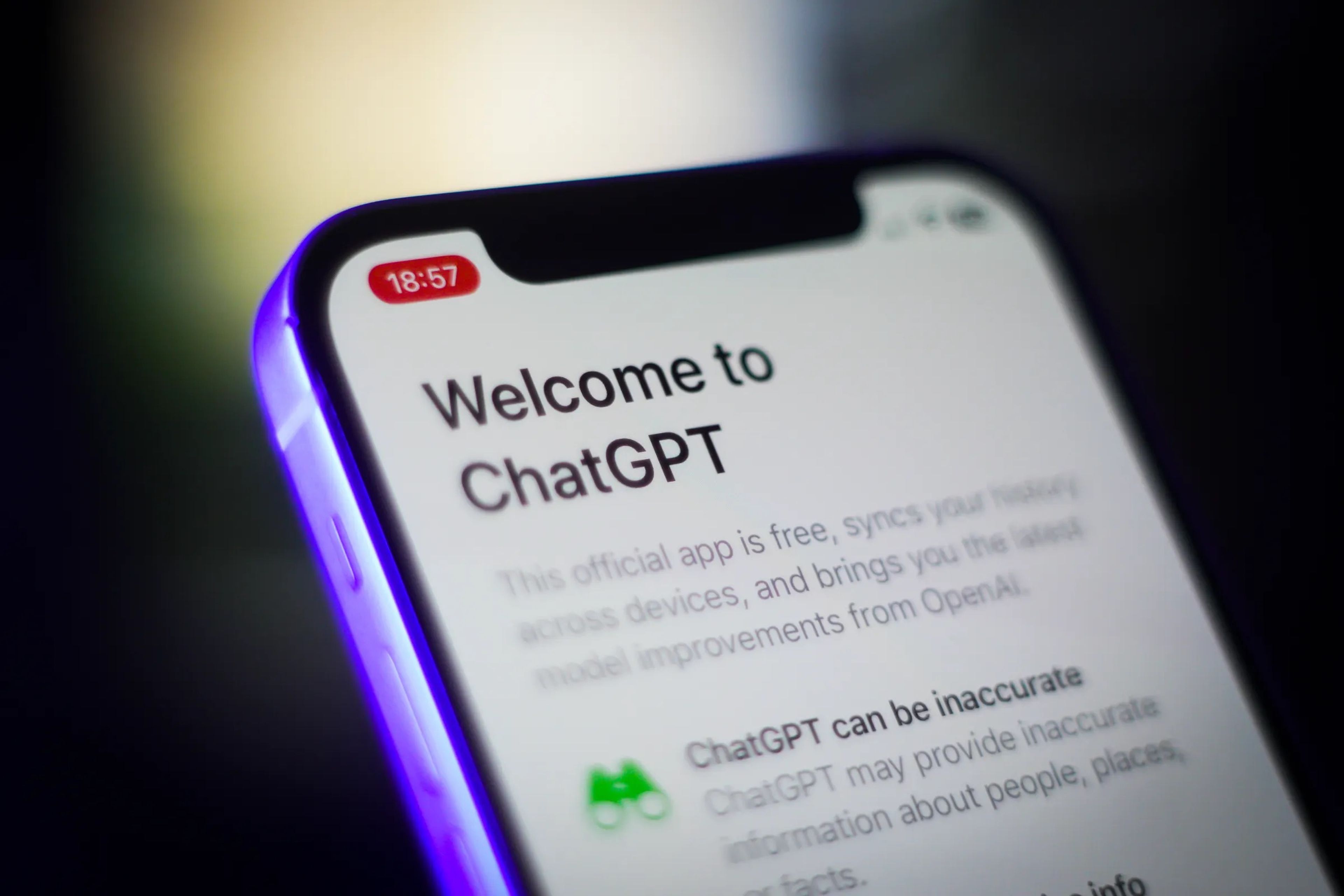 A phone shows the official app for ChatGPT