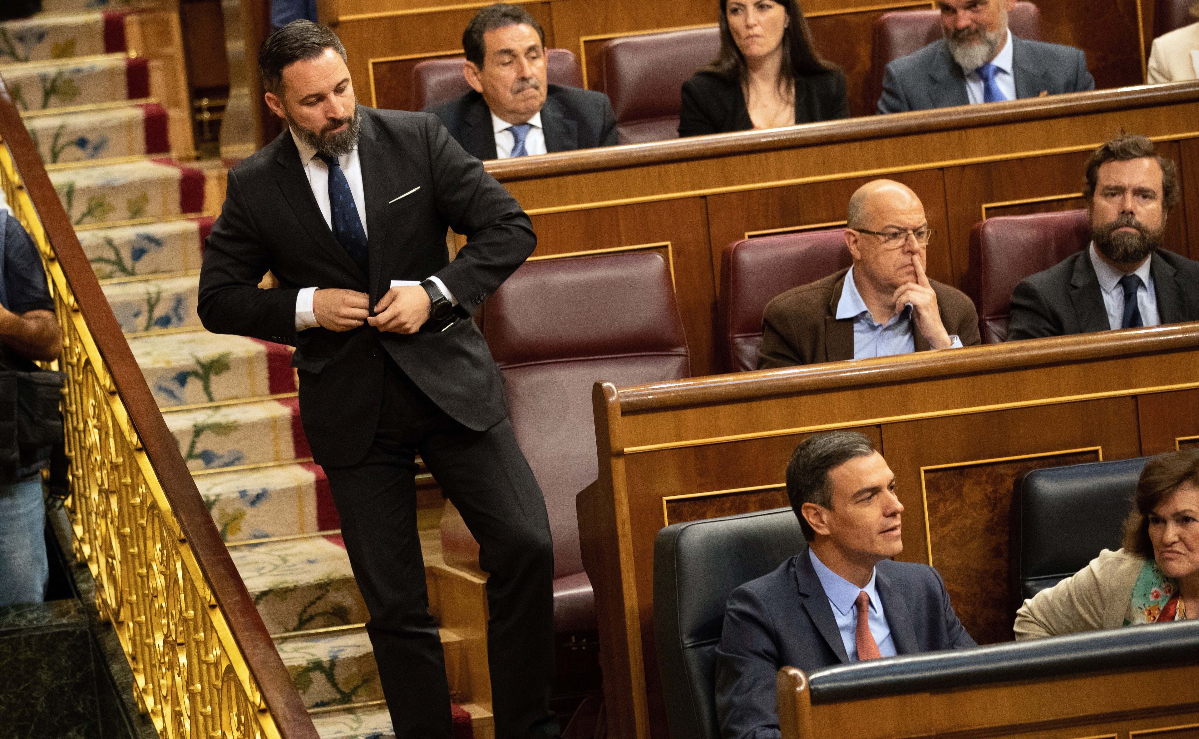 Santiago Abascal saliendo del escaño en el Congreso de los Diputados mientras mira a Pedro Sánchez.