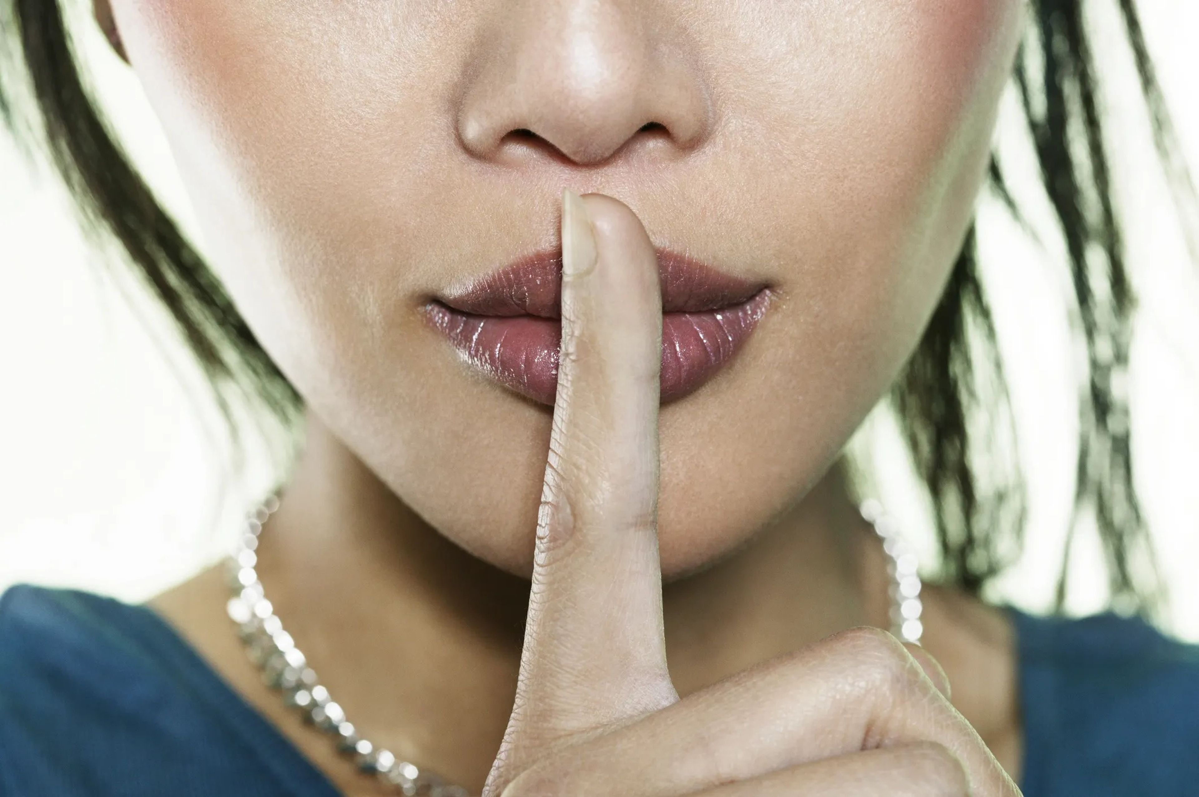 Shhh woman holding finger to lips quiet secret