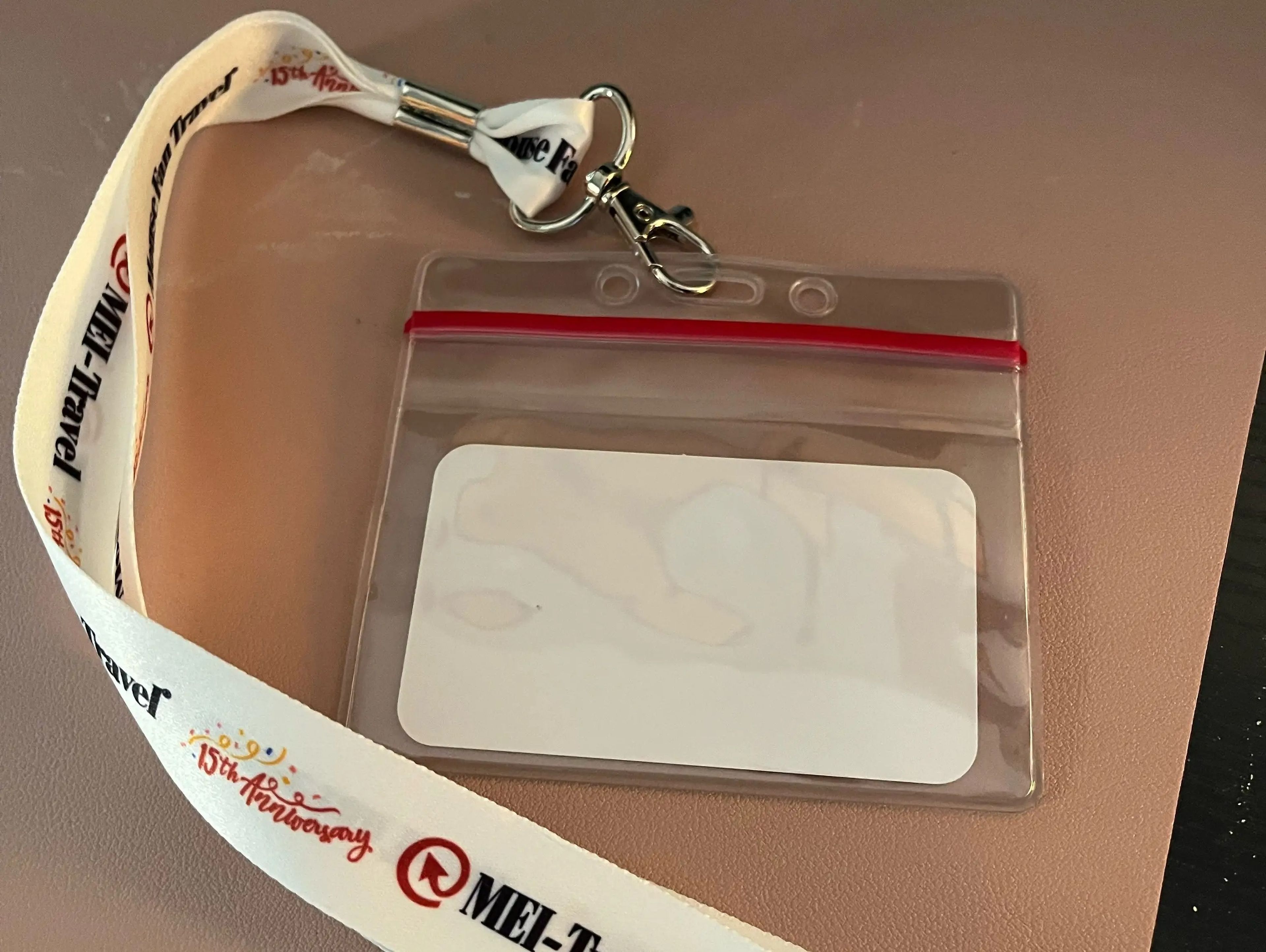 white lanyard with clear card case on a table