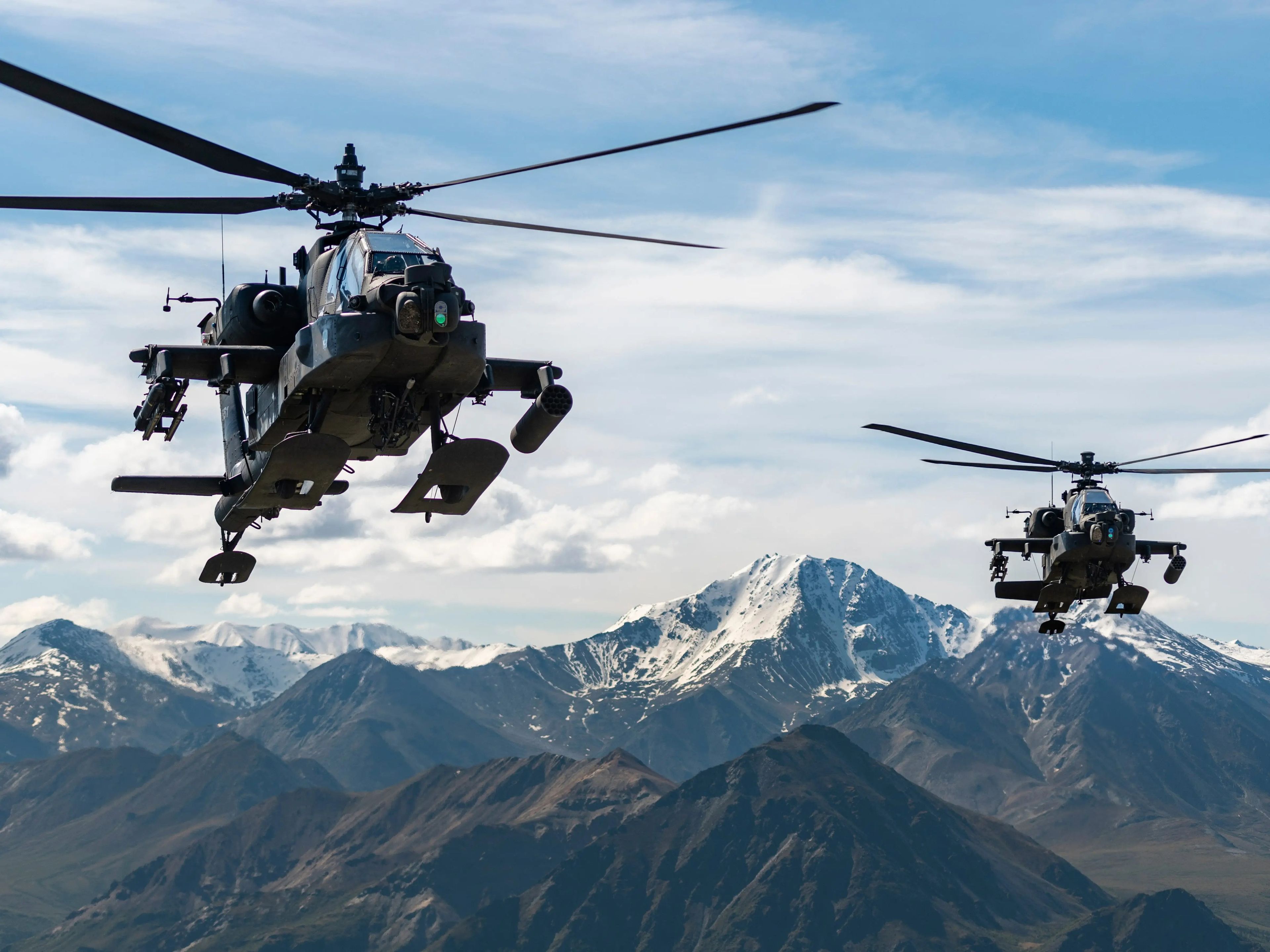 Helicópteros de ataque AH-64D Apache Longbow sobrevuelan una cadena montañosa cerca de Fort Wainwright, Alaska, el 3 de junio de 2019.