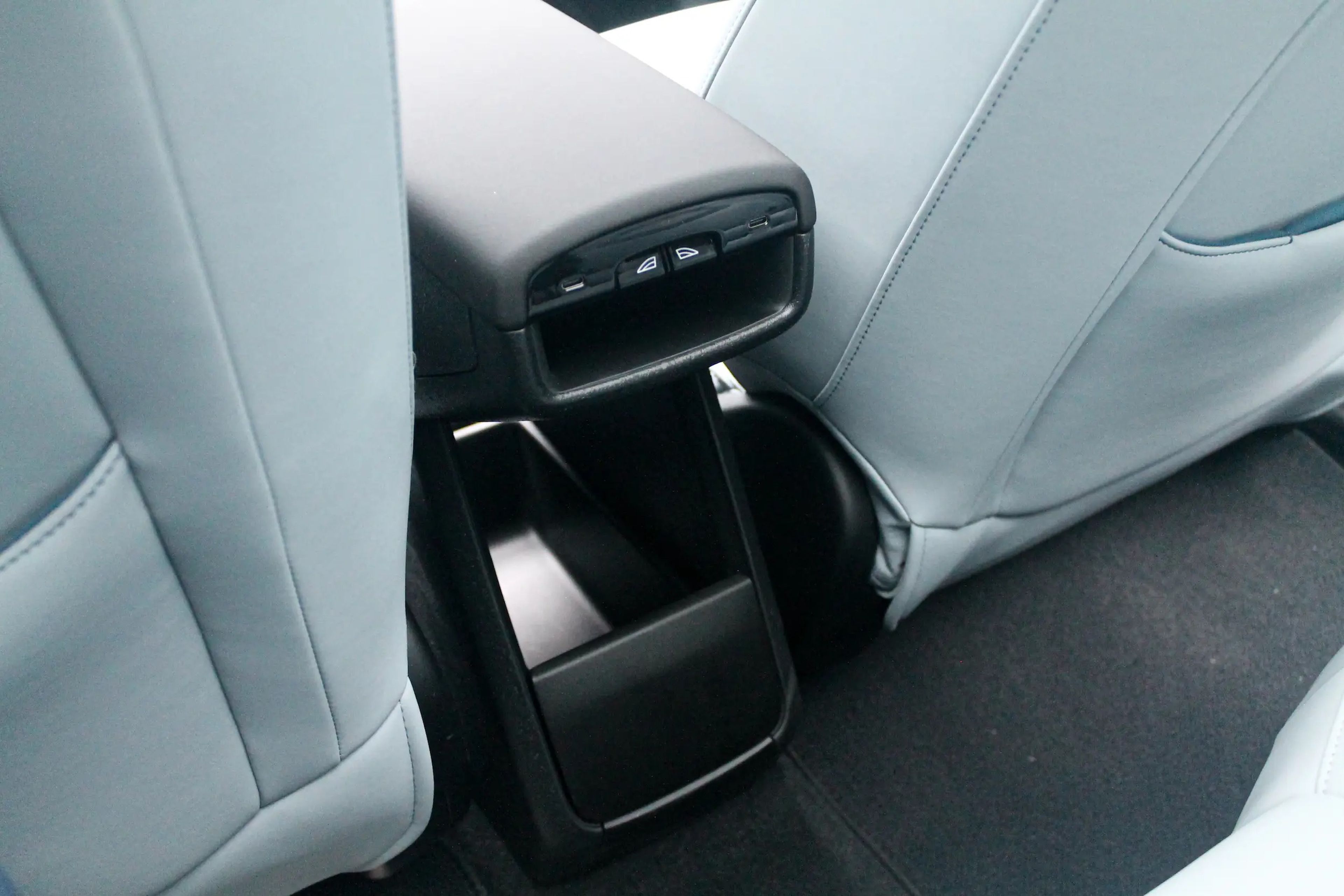 La parte trasera del reposabrazos central del Volvo EX30, que cuenta con varios puertos USB-C e interruptores para las ventanillas en la parte posterior.