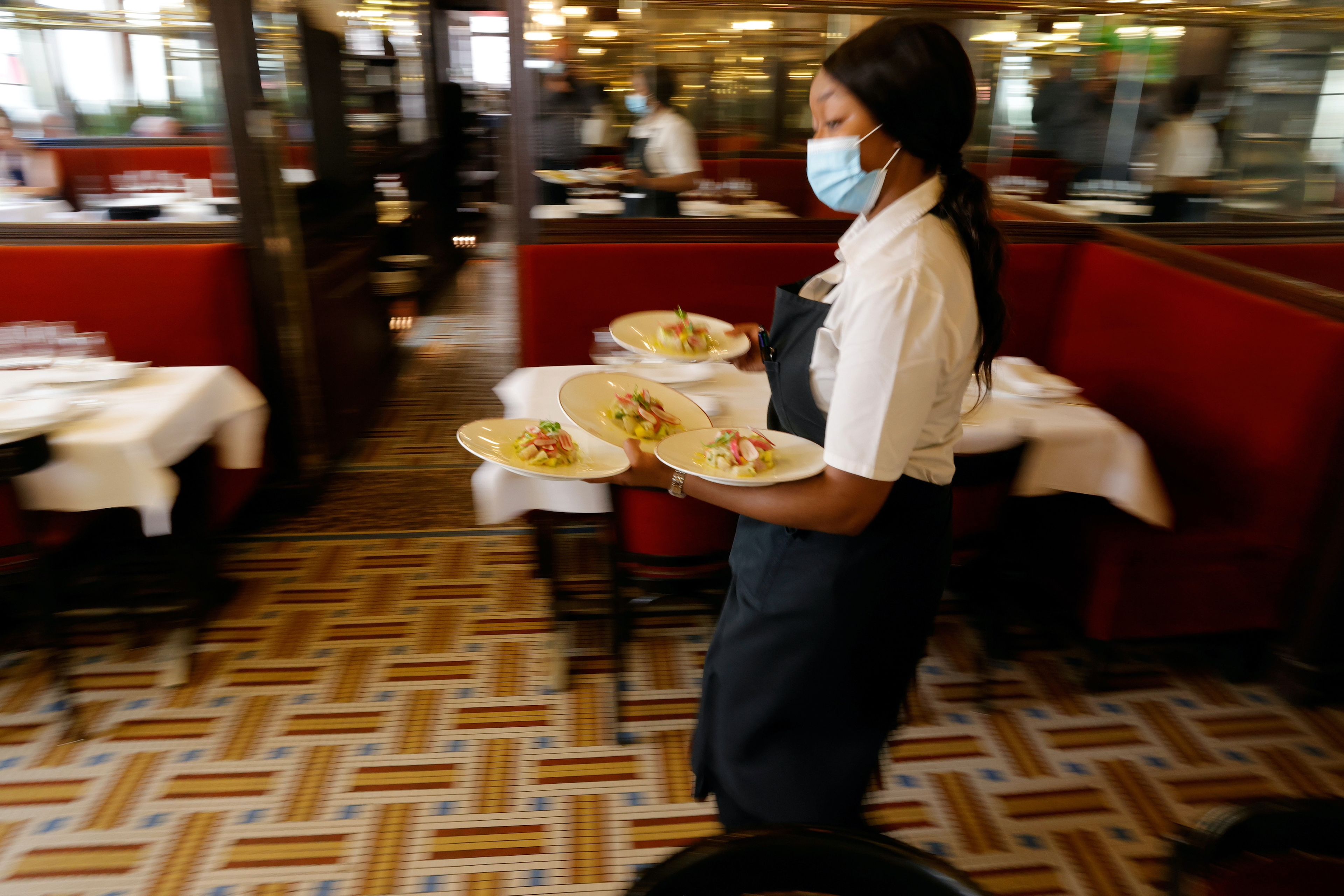 Una camarera en un restaurante sirve platos