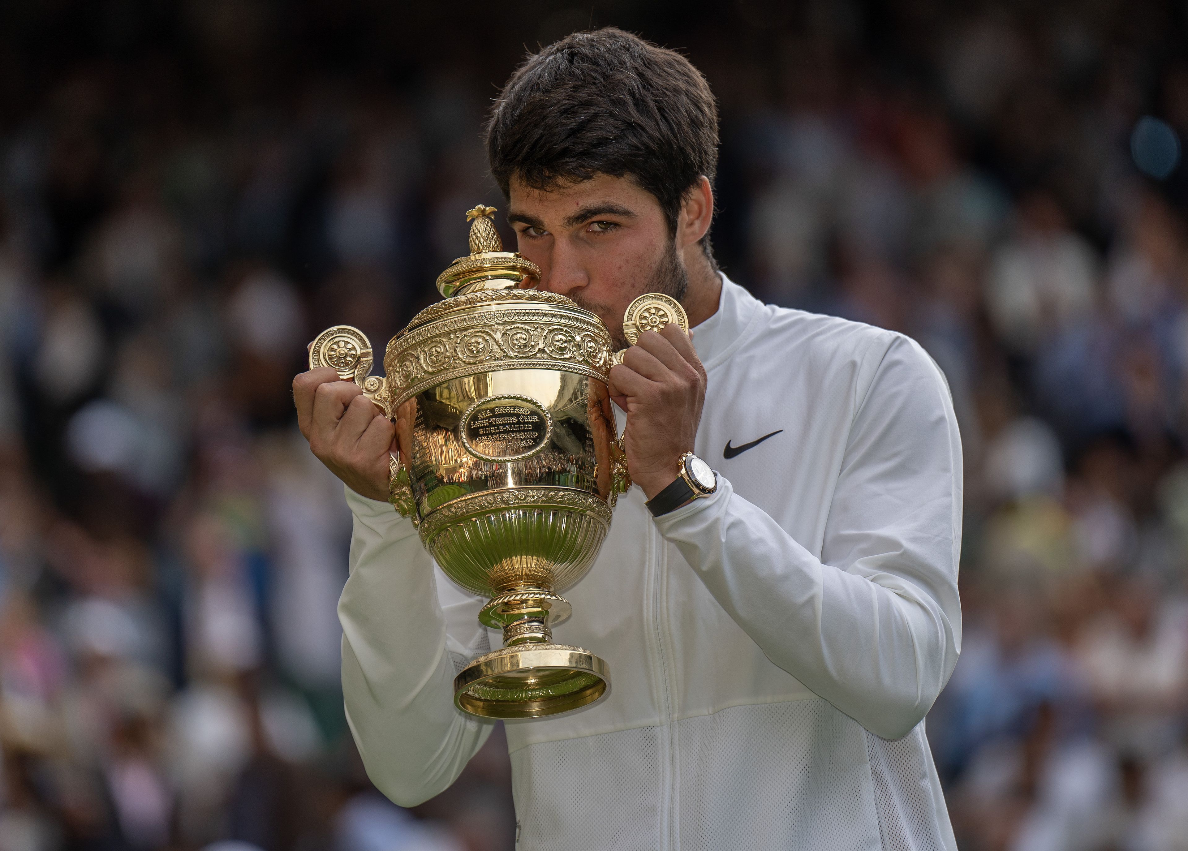 Carlos Alcaraz, ganador de Wimbledon 2023, besa el torneo.